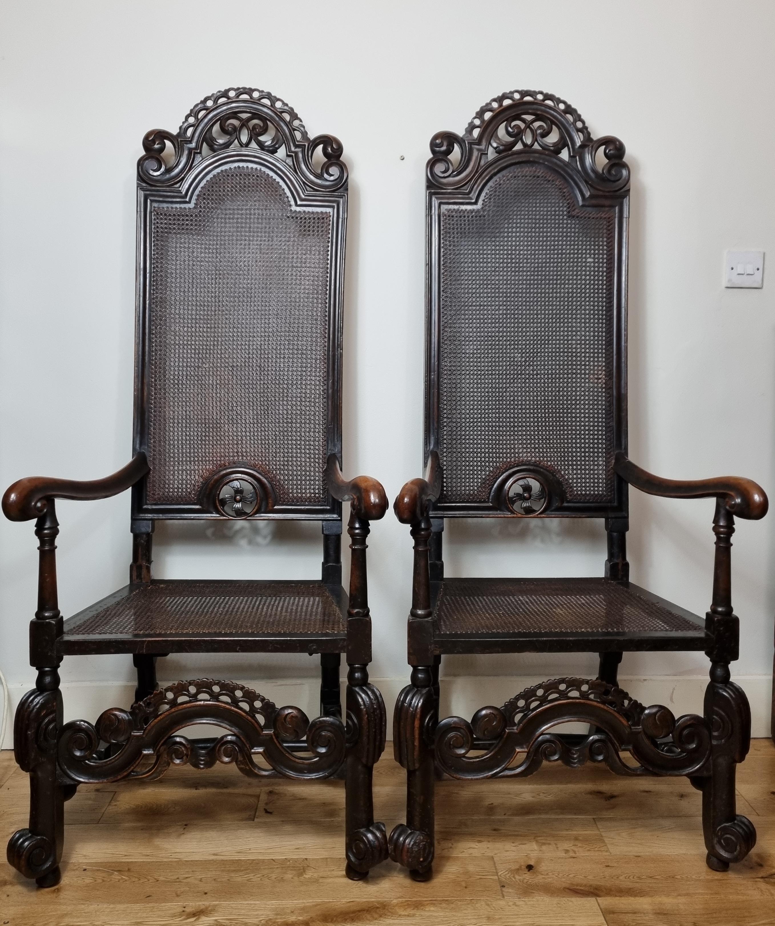 An exceptionally rare matching pair William and Mary carved walnut armchairs , dating to the late 17th century 1690s . Wonderful colour with an original deep rich patina . scrolling back rail, caned back and seat, the backs retaining their original