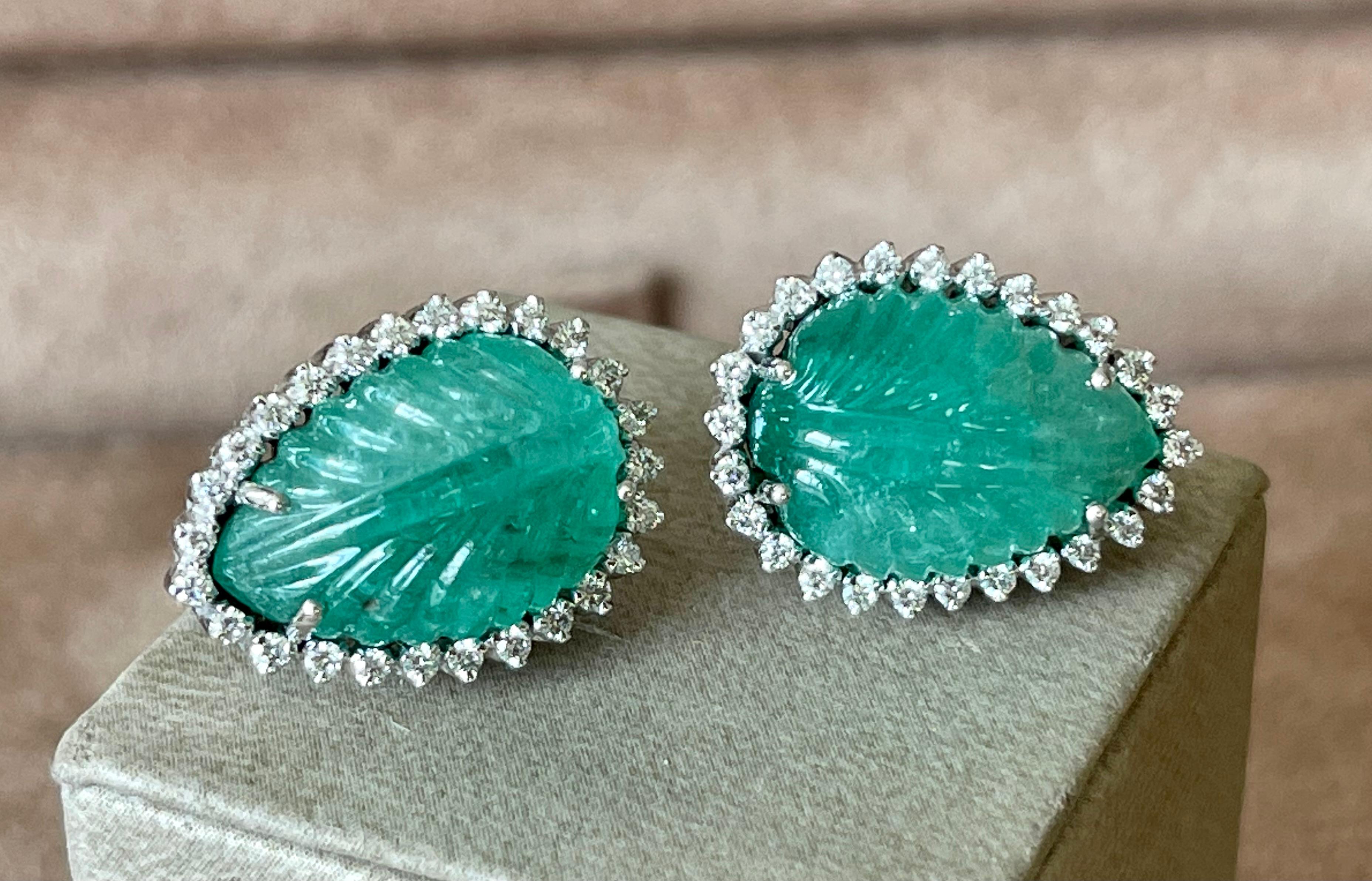 A pair of very elegant 18 K white Gold earrings featuring 2 pear shape beautifully carved Emerald Cabochons weighing 26.96 ct, both surrounded by 52 brillinat cut Diamonds weiging 0.75 ct.
Dimensions: 2.12 cm x 1.52 cm. 
Masterfully handcrafted