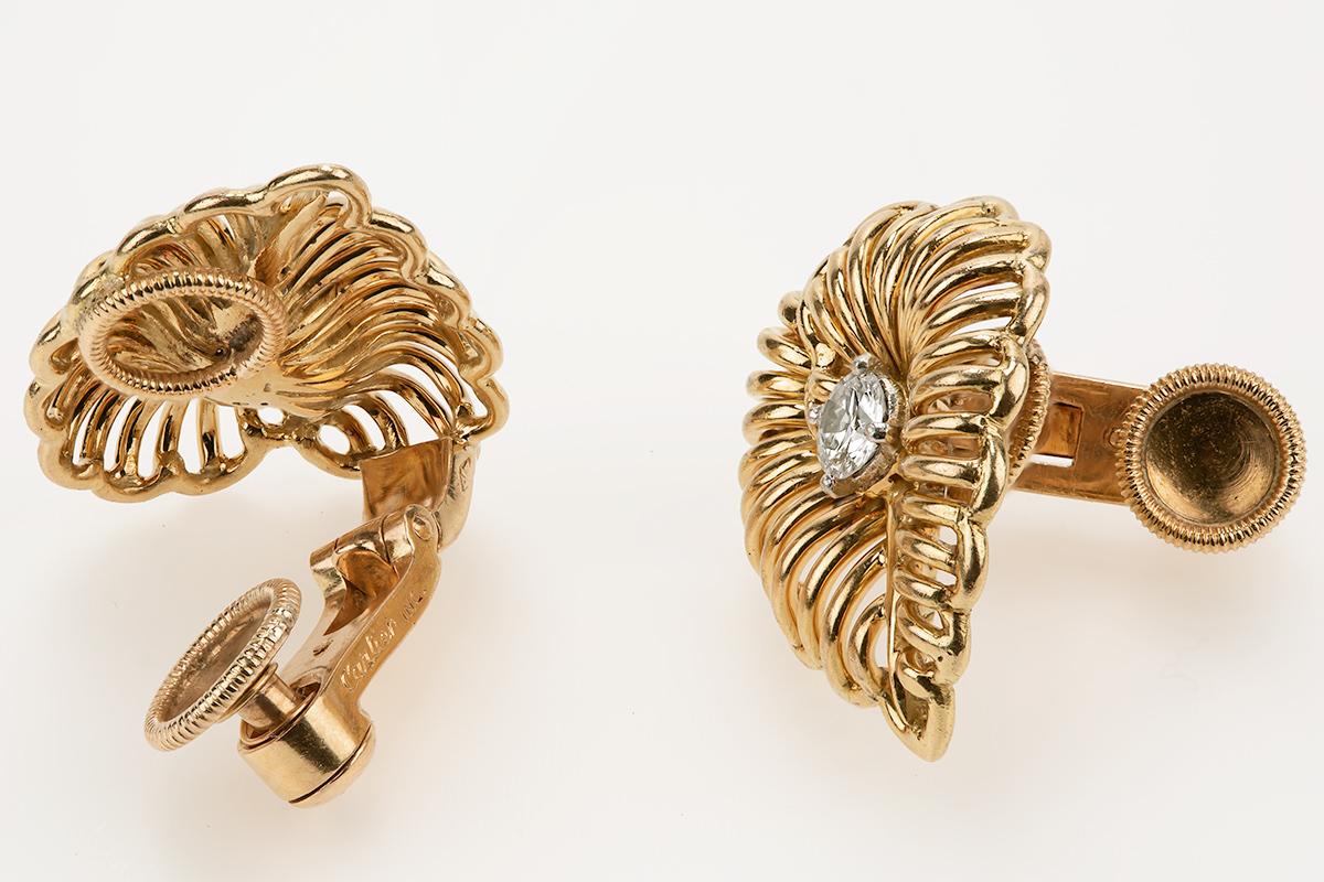 A fine quality pair of vintage Cartier earrings in 18 karat yellow gold with a single central diamond of brilliant cut. The beautiful open work design is in the shape of a leaf with a sprung clip ear fitting for comfort. Signed; Cartier inc France