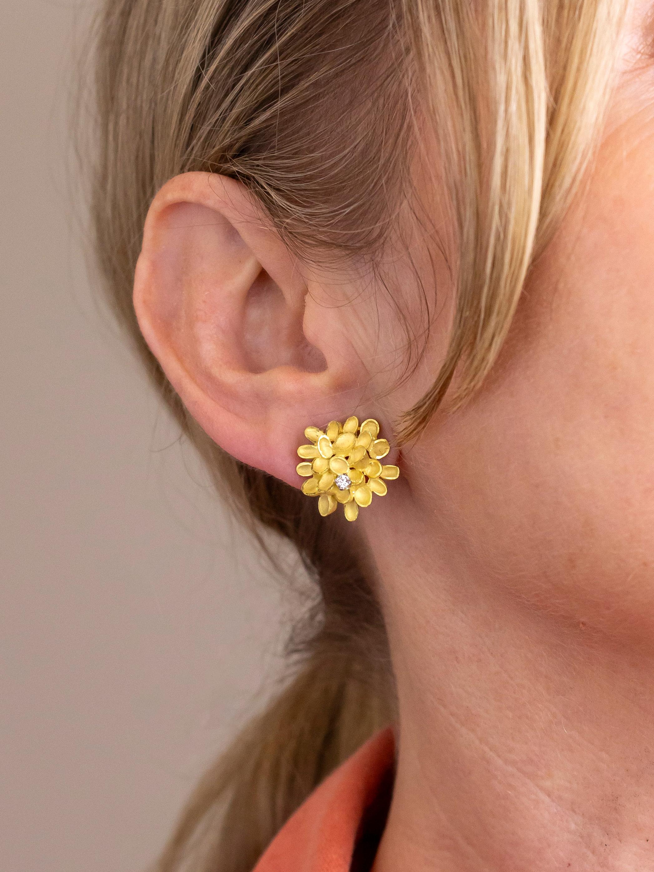 This pair of delicate ear clips are crafted from 18 karat yellow gold and are each set with a round brilliant cut diamond. The clips are by famed London jeweller Andrew Grima who has been described as 'the father of modernist jewellery' and was