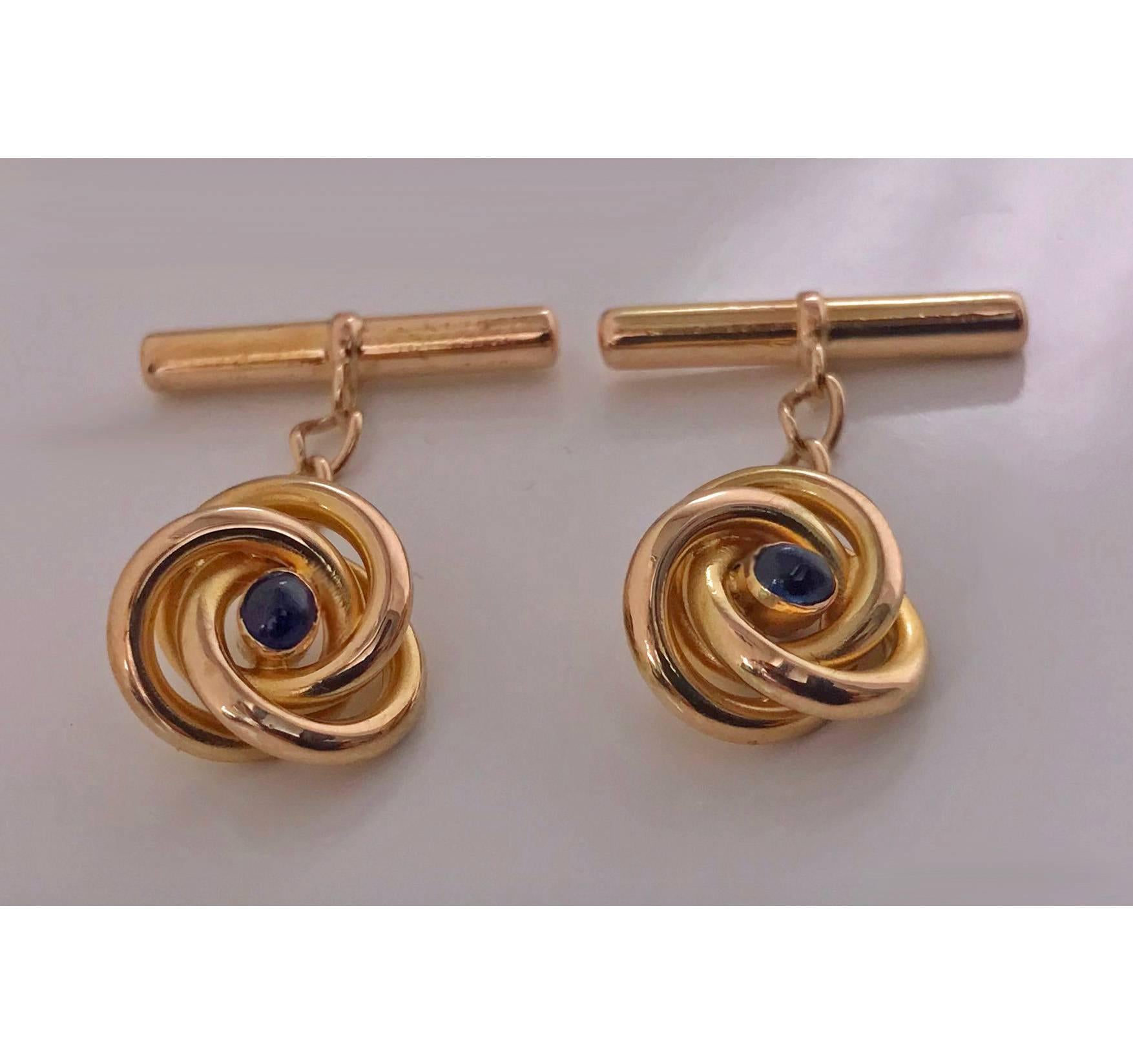 Pair of 18K (tested) Sapphire  Cufflinks, C.1930. Each of open swirl knot design, set with small oval cabochon blue sapphire, 14K t bar fitments chain link between. Total Item Weight: 4.59 gm. Continental mark, possibly French.