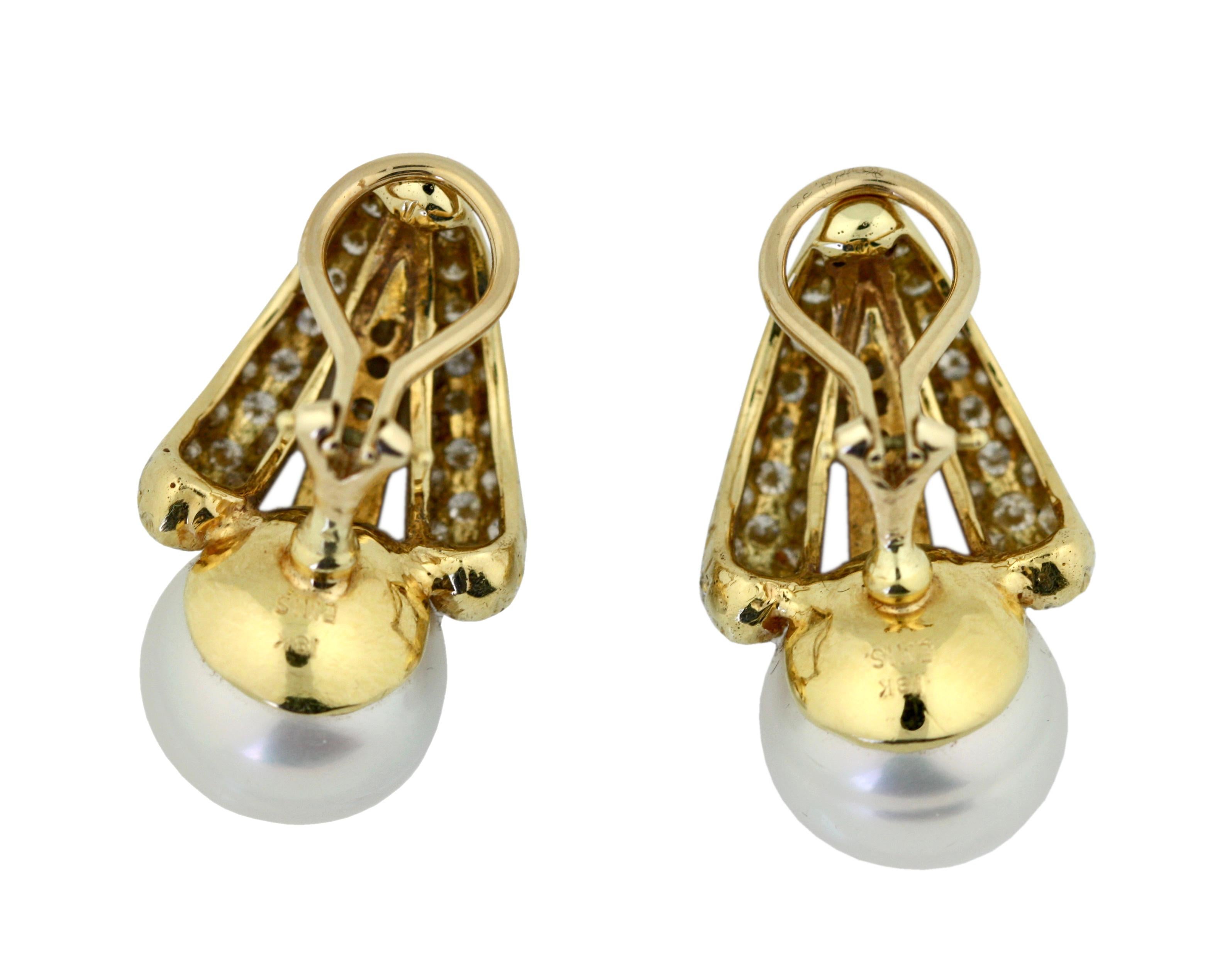 
Pair of 18 Karat yellow Gold, Cultured Pearl and Diamond Earclips, Emis
Topped by two round-shaped cultured pearls measuring approximately 13.5 by 13.5 mm, set with round diamonds, signed Emis.