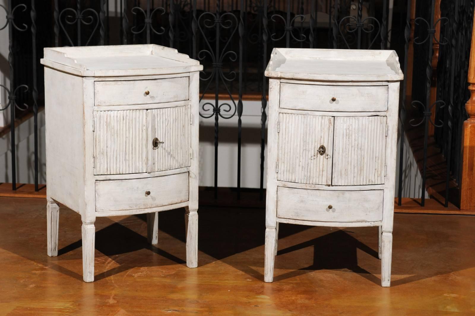A pair of Swedish Gustavian early 19th century painted wood bedside tables from Göteborg with drawers and doors. Born during the early years of the 19th century in the Southwestern city of Göteborg (Gothenburg), each of this pair of Swedish bedside