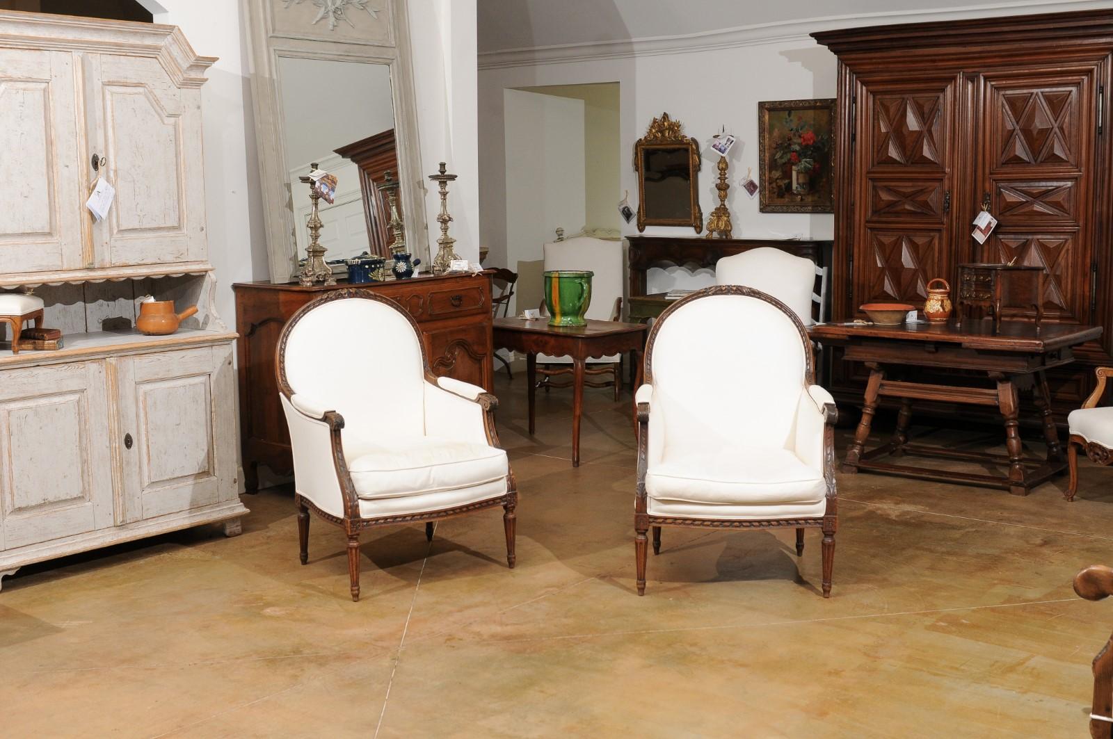 19th Century Pair of 1830s French Restauration Carved Walnut Upholstered Bergères Chairs
