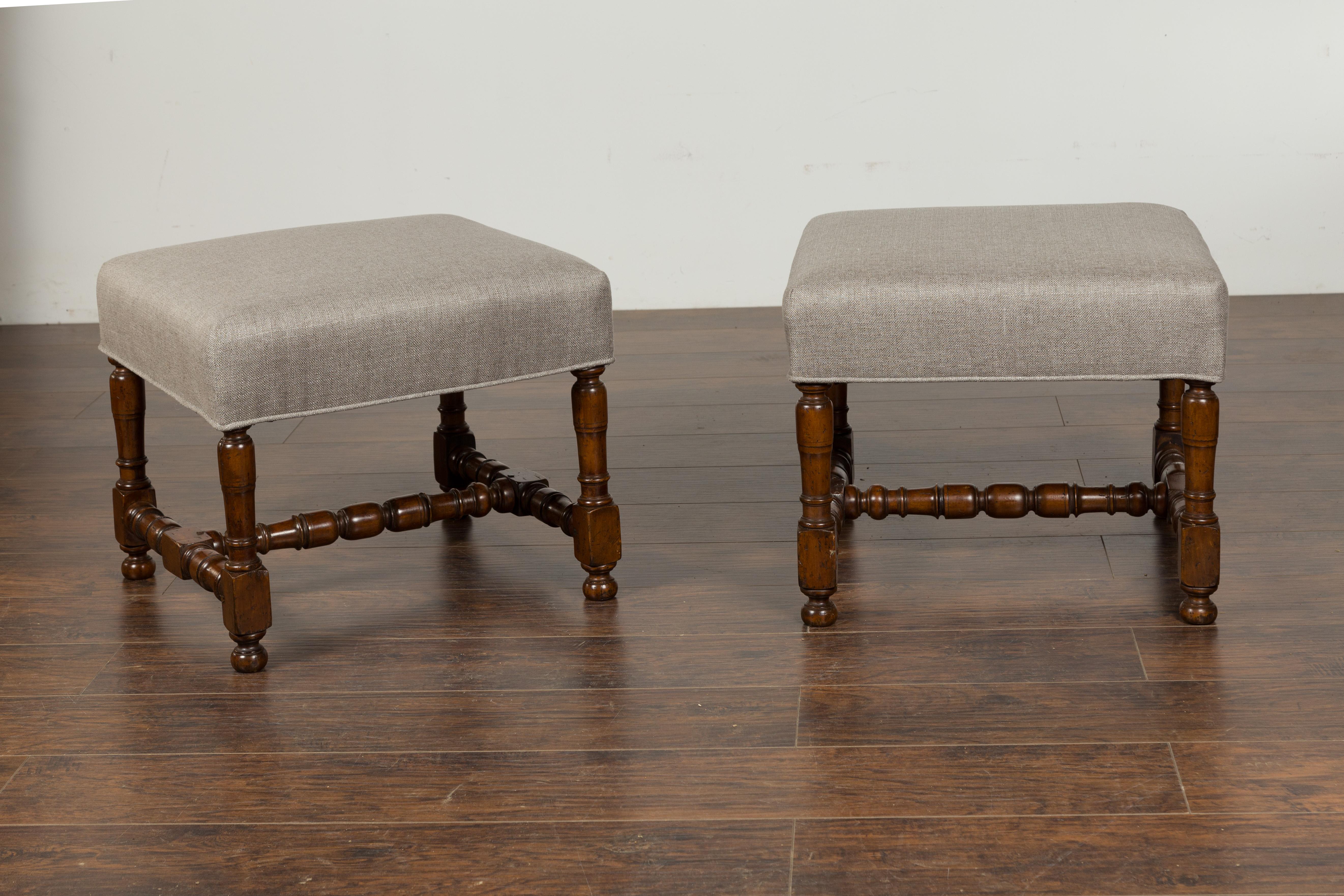 A pair of English walnut stools from the late 19th century, with new upholstery. We currently have two pairs available, priced and sold per pair: $5,400. Created in England during the third quarter of the 19th century, each of this pair of walnut