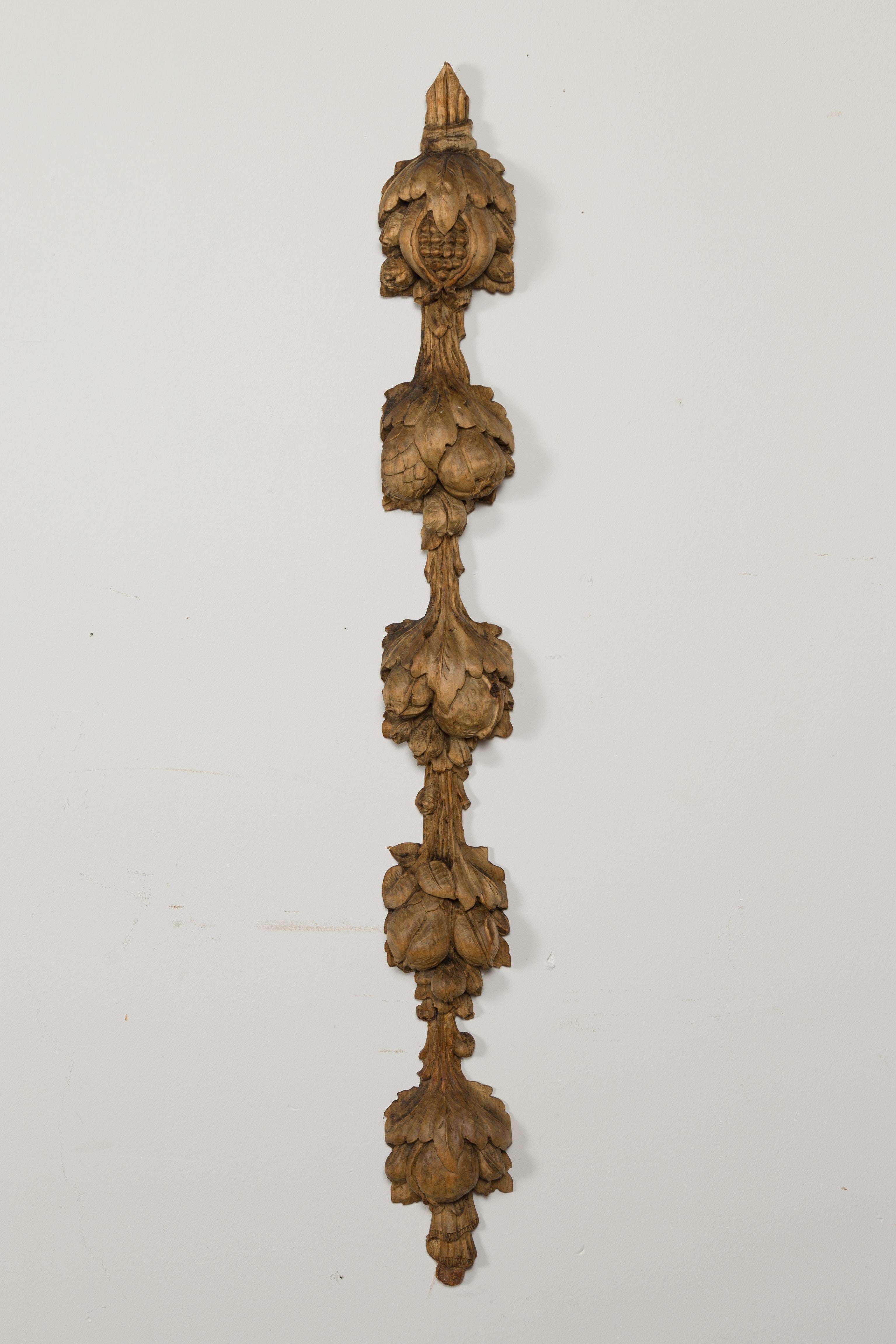 A pair of Italian carved wooden wall carvings from the late 19th century, depicting pomegranates. Created in Italy during the last quarter of the 19th century, each of this pair of vertical wall fragments features an elegant arrangement of
