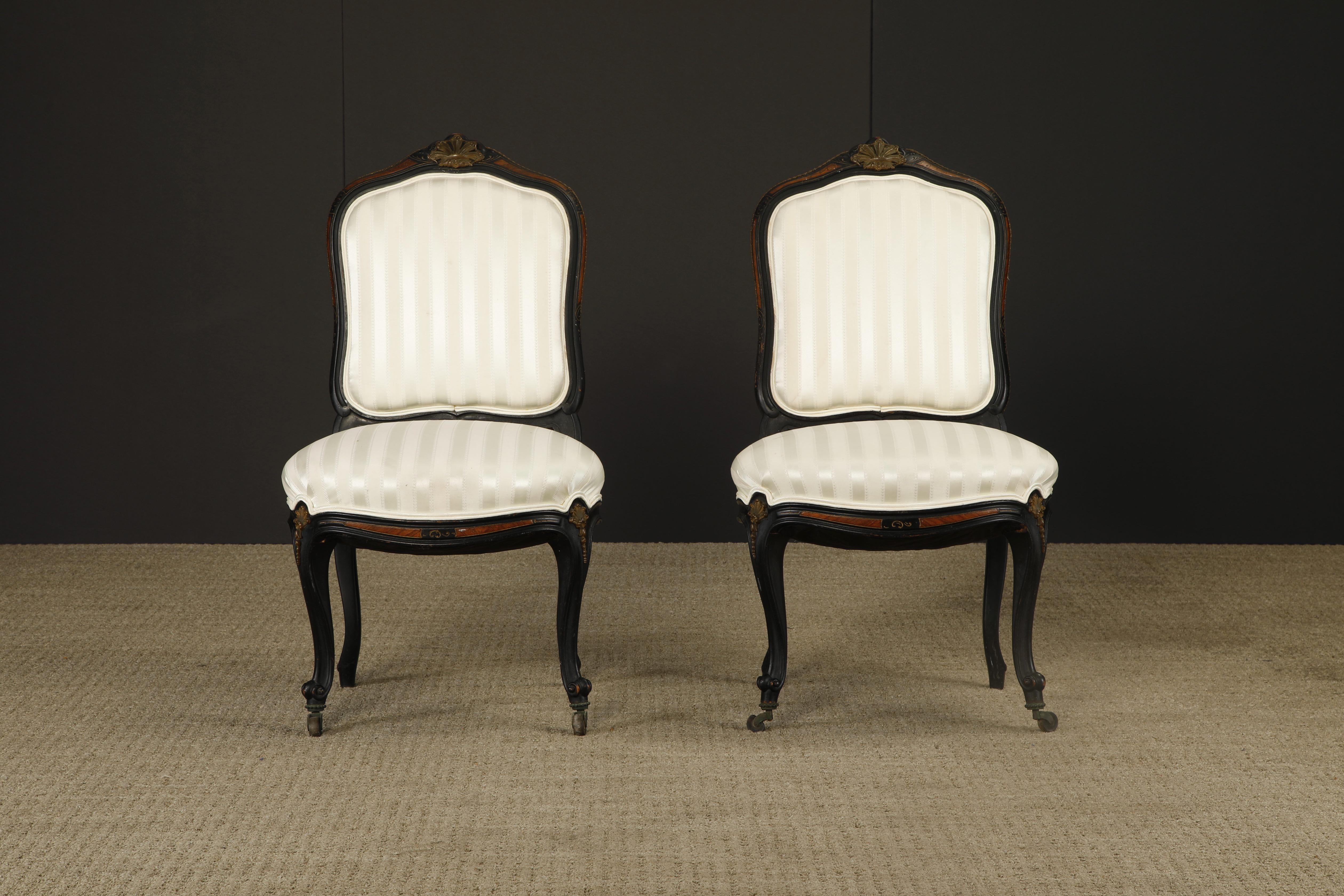 This intriguing pair of 1890s French Louis XV style chairs in the style of Rinquet-Leprince feature elaborate carving of ebonized wood, gilt details, and Mahogany inlay with upholstered seats and seat backs and front casters.

Ideal candidates for