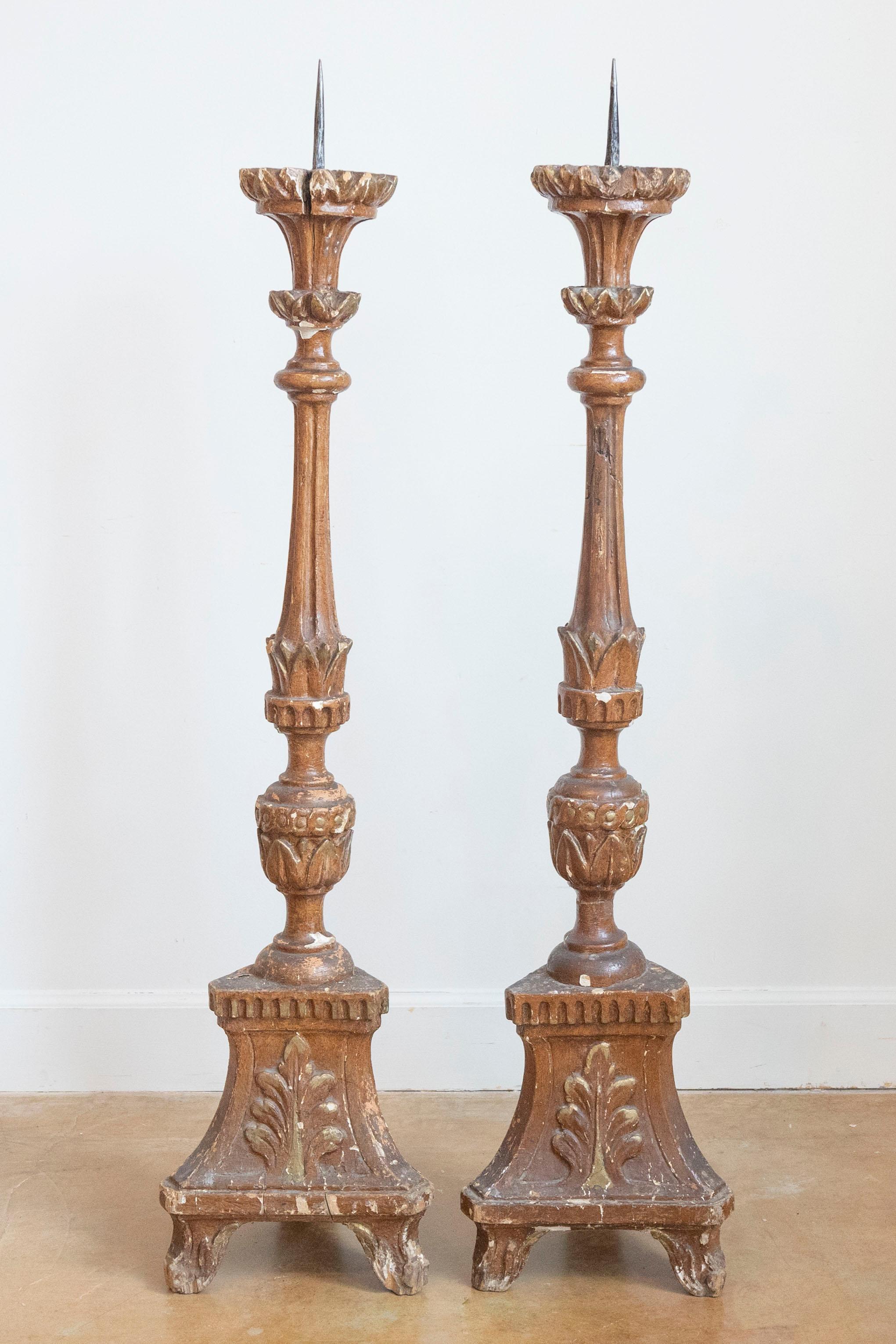 Coppia di candelabri francesi dipinti in grande scala della fine del XIX secolo, con patina rovinata e motivi a fogliame. Creata in Francia nell'ultimo decennio del XIX secolo, questa coppia di candelieri presenta una colonna centrale ornata da