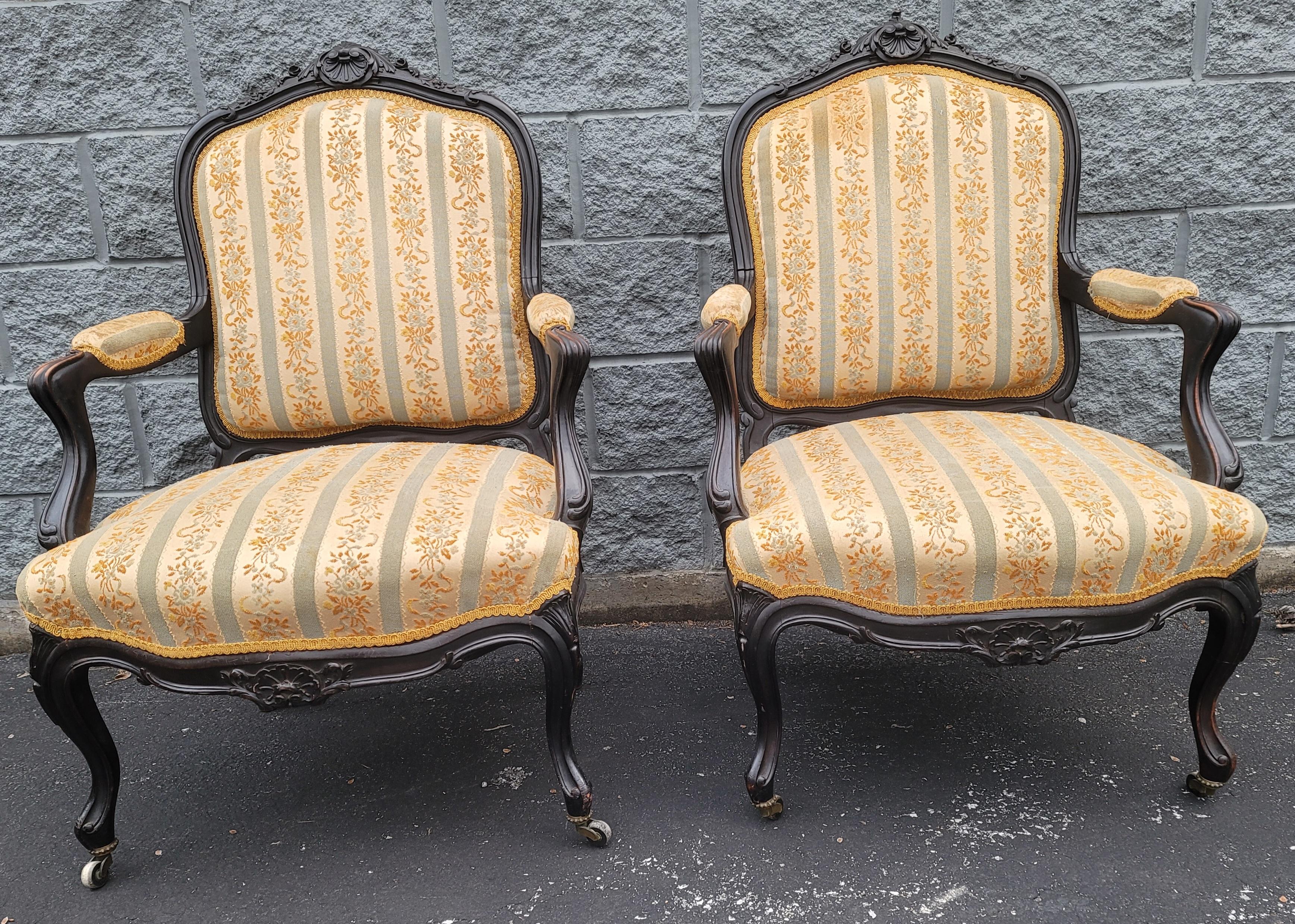 Pair of  1890s Louis XV Carved, Ebonized and Upholstered Lounge Chairs. Quality striped upholstery. Nicely ebonized and carved. Very firm and comfortable seats. Measures 27