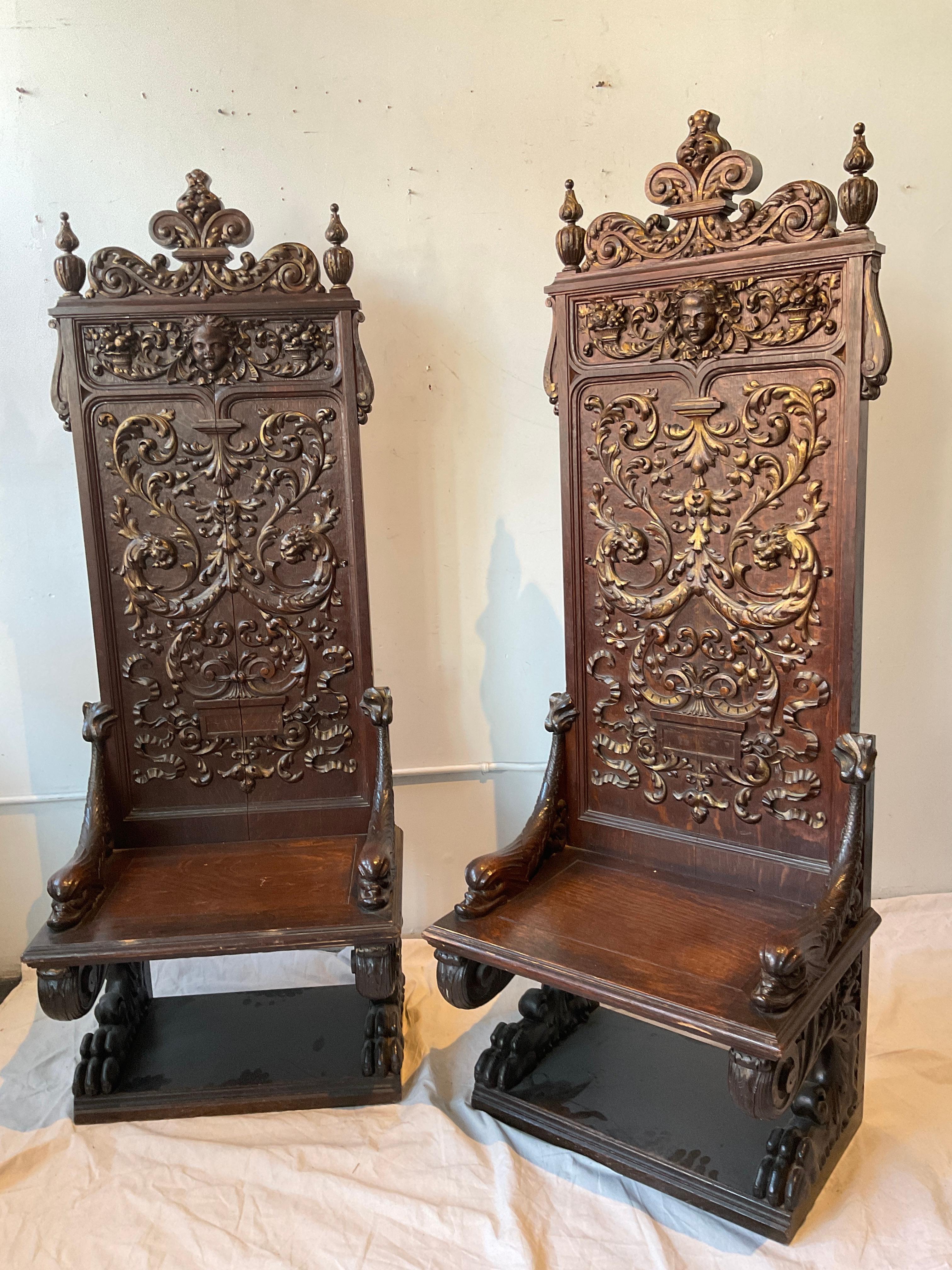 Pair of 1890s tall Gothic wood chairs  Faces, panthers, cornucopias, dolphins, lion paws all carved into the wood.
Split down middle of chair as shown in last image.