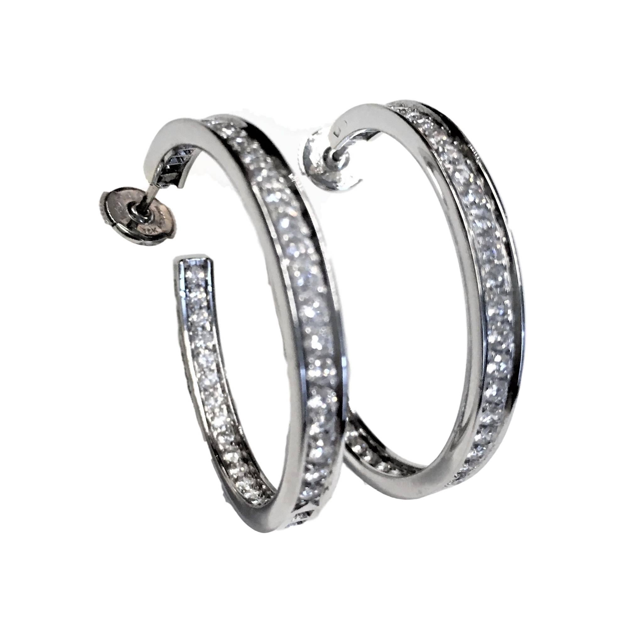 18k white gold Cartier diamond hoop earrings. Each set with round brilliant cut diamonds.
Total weight of approximately 3ct,  The earrings measure 34mm in height and 2.5mm in width and 
Posts with alpa back fittings. 
Signed Cartier. Numbered.