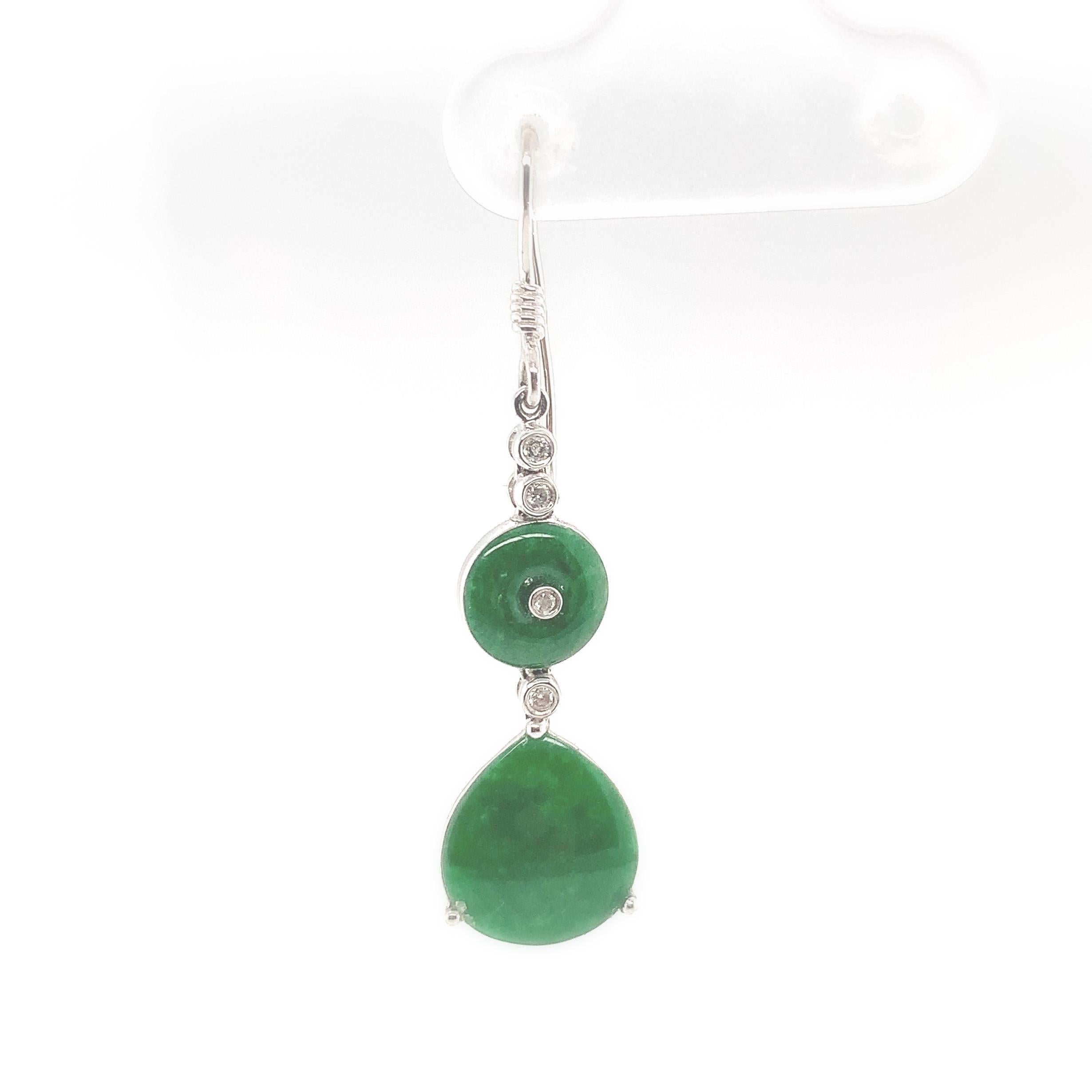 A pair of 18K white gold drop earrings featuring green jadeite jade and diamonds. Each earring has a round disk shape jade and a rounded pear shaped jade drop. The round jade measures about 7mm diameter and the rounded pear measures about 10mm x