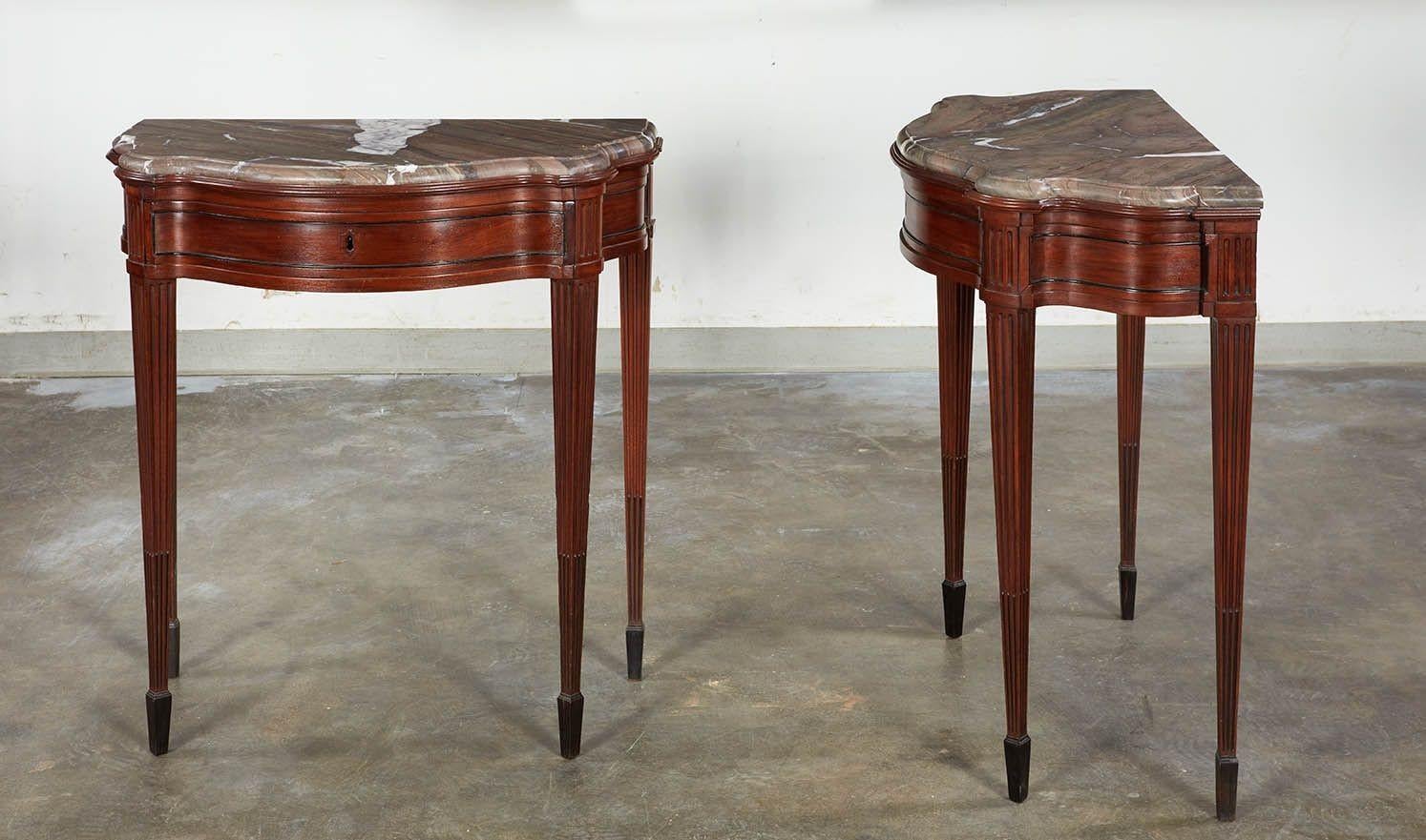 Fine pair of 18th century northern Italian mahogany console tables having graceful stance and proportions. Impressively marbled thick tops above shaped aprons with single drawers and ebonized molding, the tapered legs with fluting and ebonized stop