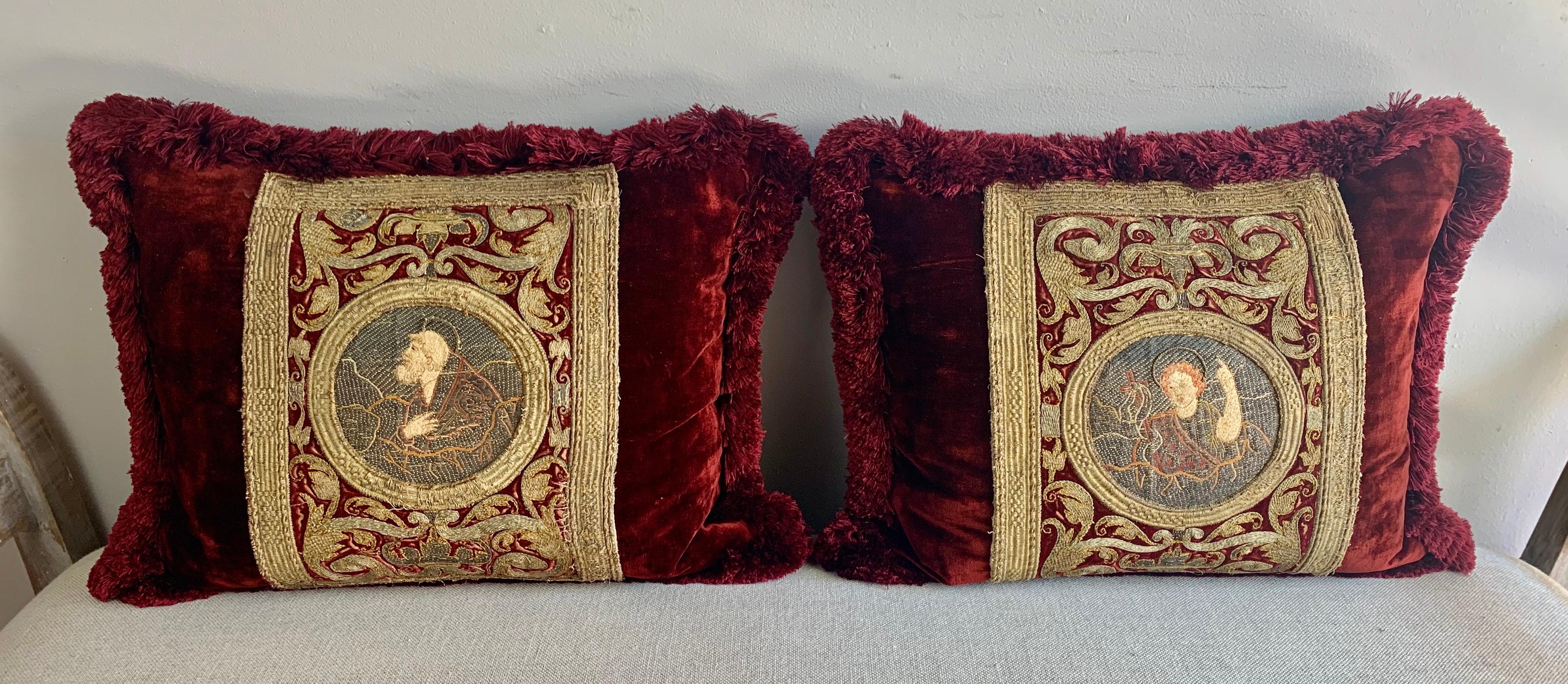 Pair of incredibly fine 18th century metallic and silk embroidered red and gold textile pillows. The pillows depict religious apostles centered in cartouches and surrounded by more incredible embroidery throughout. Silk taffeta backs, multicolored