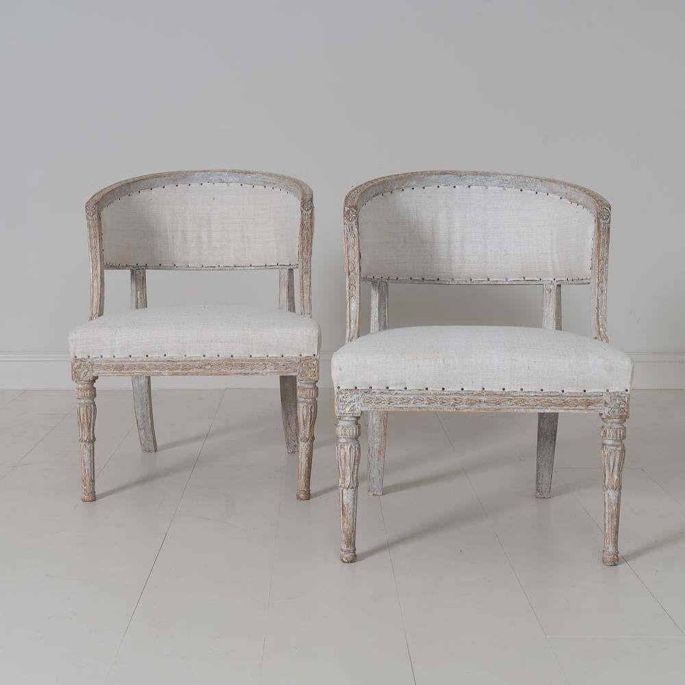 A pair of Swedish chairs with classic sulla barrel backs from the Gustavian period wearing original paint and newly upholstered in linen. Beautifully carved bell flowers around the backs of the chairs and on the seat frame, rosettes on the corner
