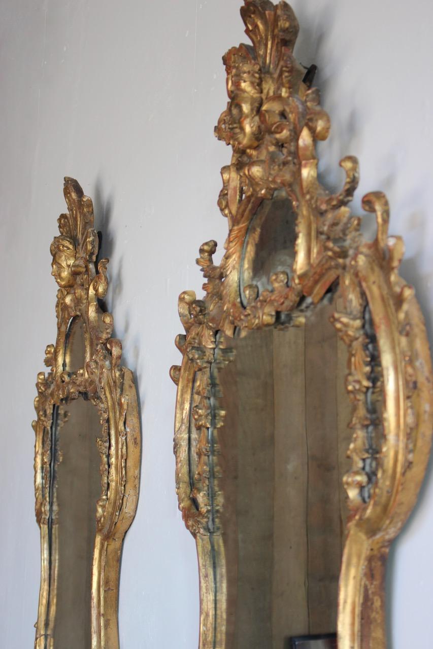 A fine and impressing pair of 18th century Italian carved giltwood mirrors of great size and proportions, with original handcut back boards and blacksmith made metal hooks and nails.
Italy.
  