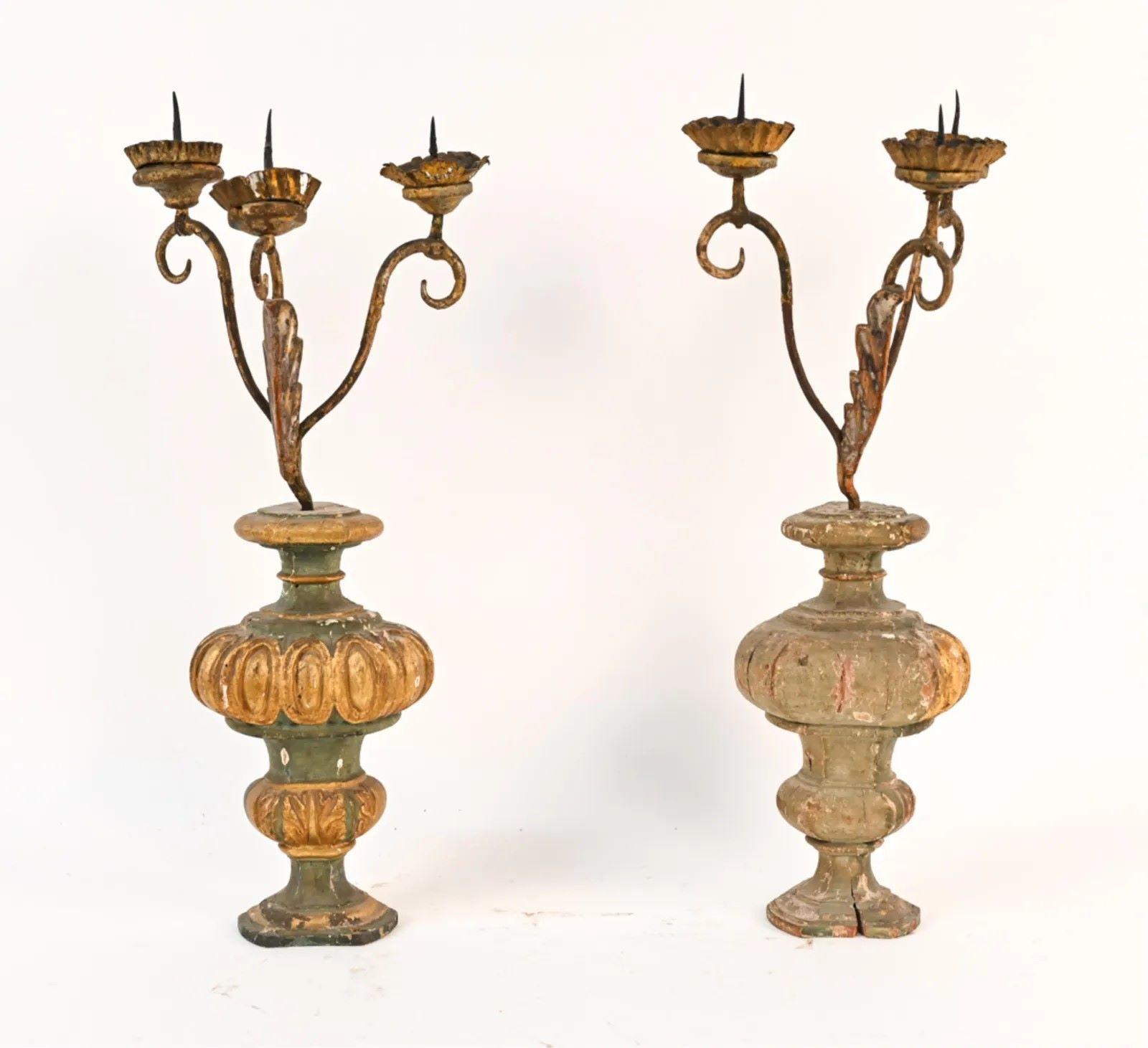 A charming pair of 18th century or earlier altar candle holders, each with 3 tole and wrought iron arms on a gesso and parcel gilt decorated wood urn-form base.