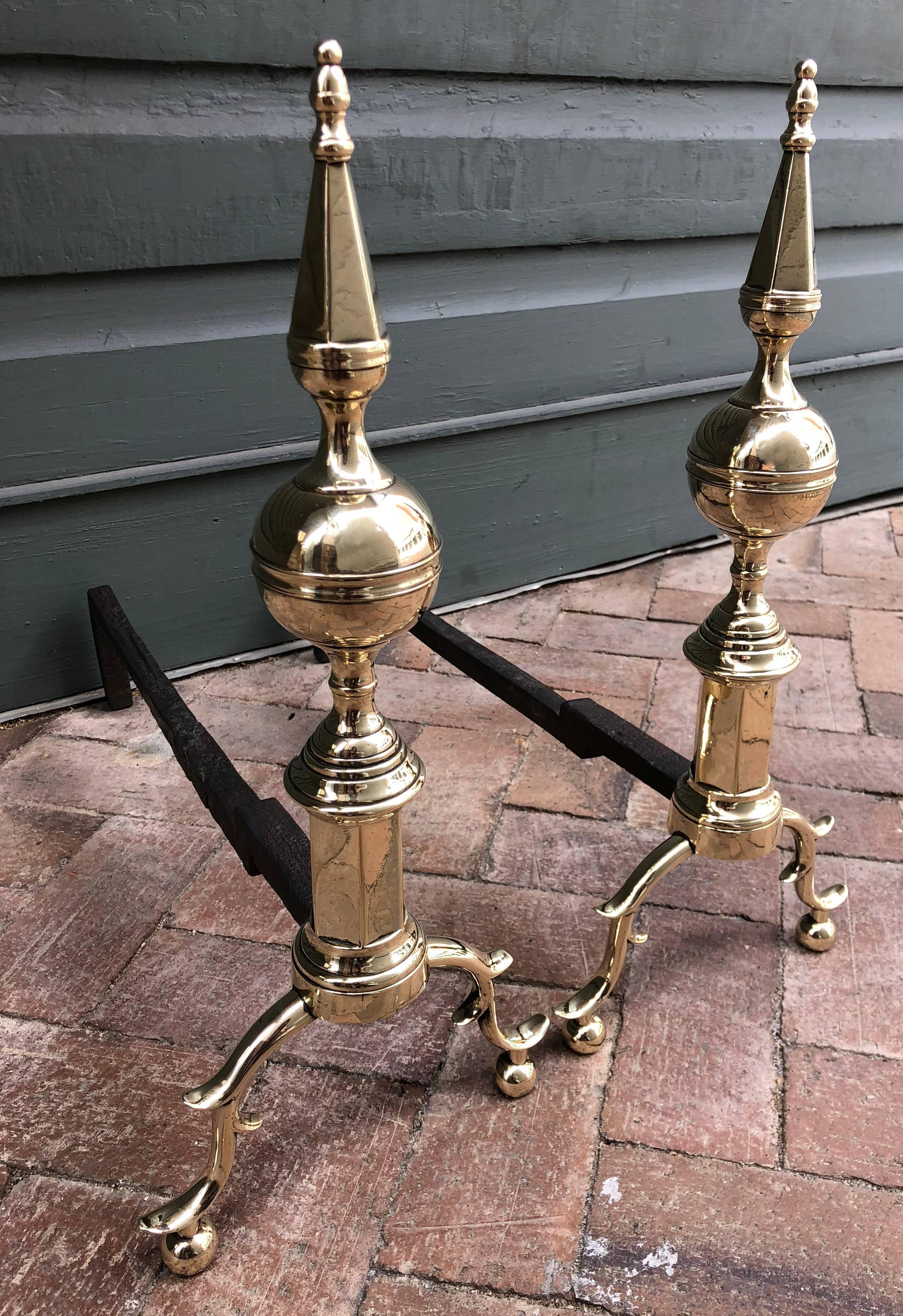 Late 18th century American New York steeple top andirons with S-scrolled legs and spurs ending in ball feet. The body is brass with hand-wrought iron shaft.