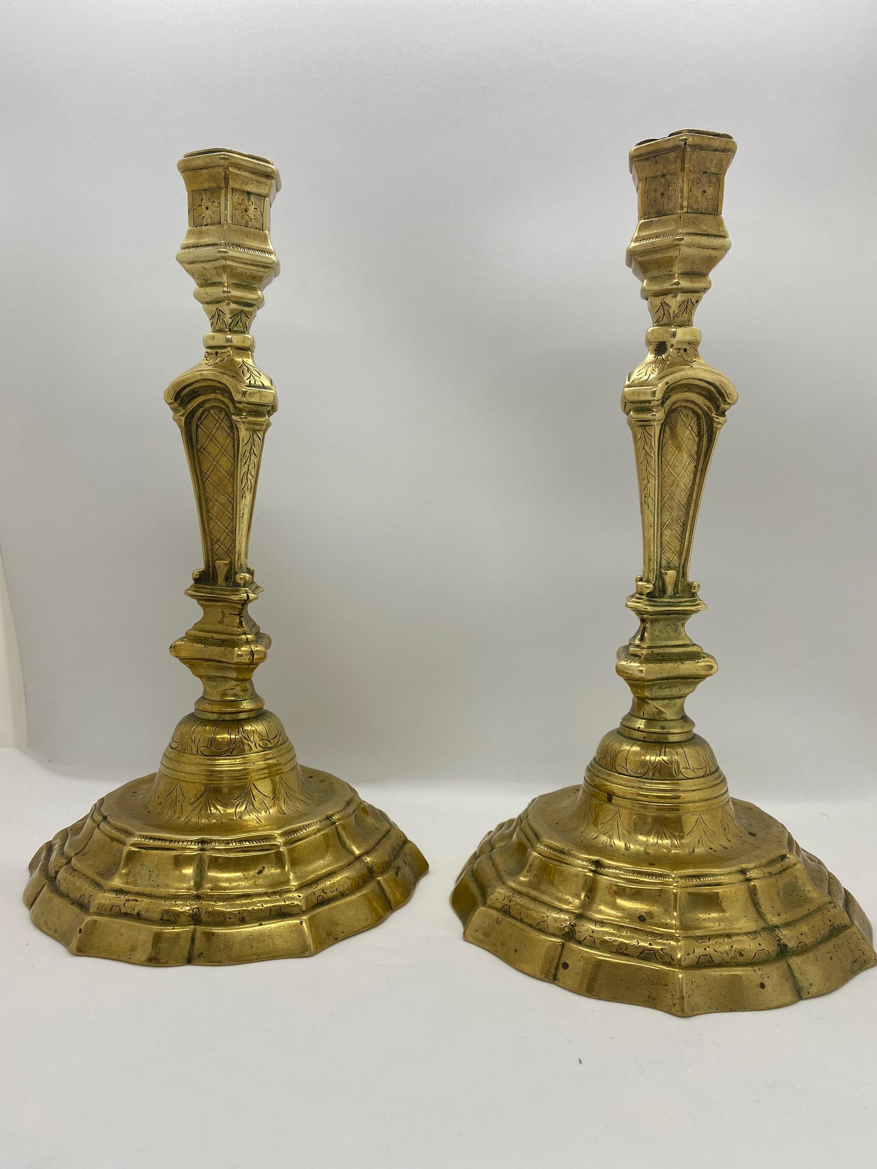 A pair of 18th century candlesticks, French. Originally these have been silvered but the silver is now al worn away except small traces.