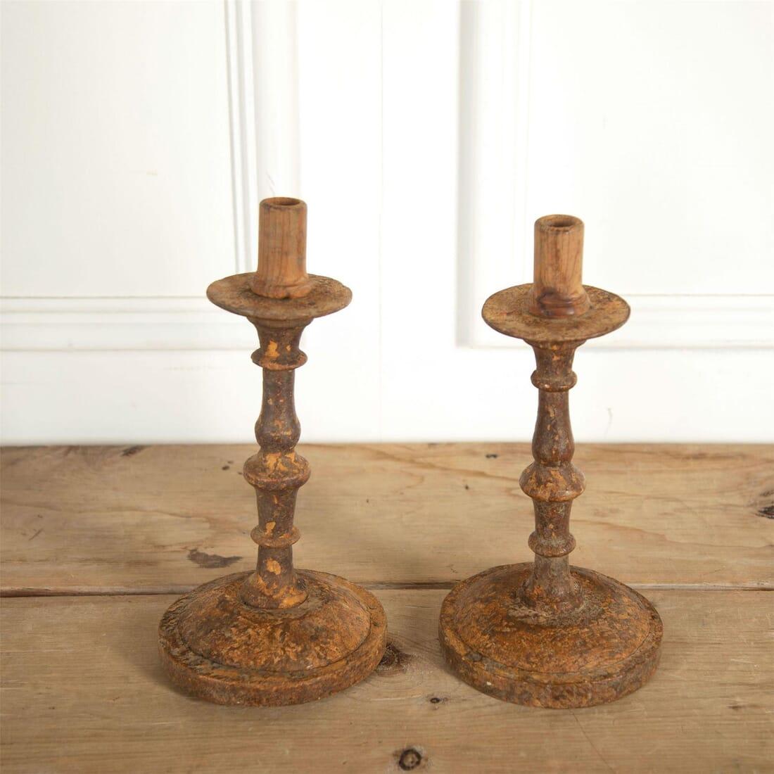 A rare pair of 18th century wooden candlesticks, with later candleholders added. These rustic antique candlesticks exude charm.