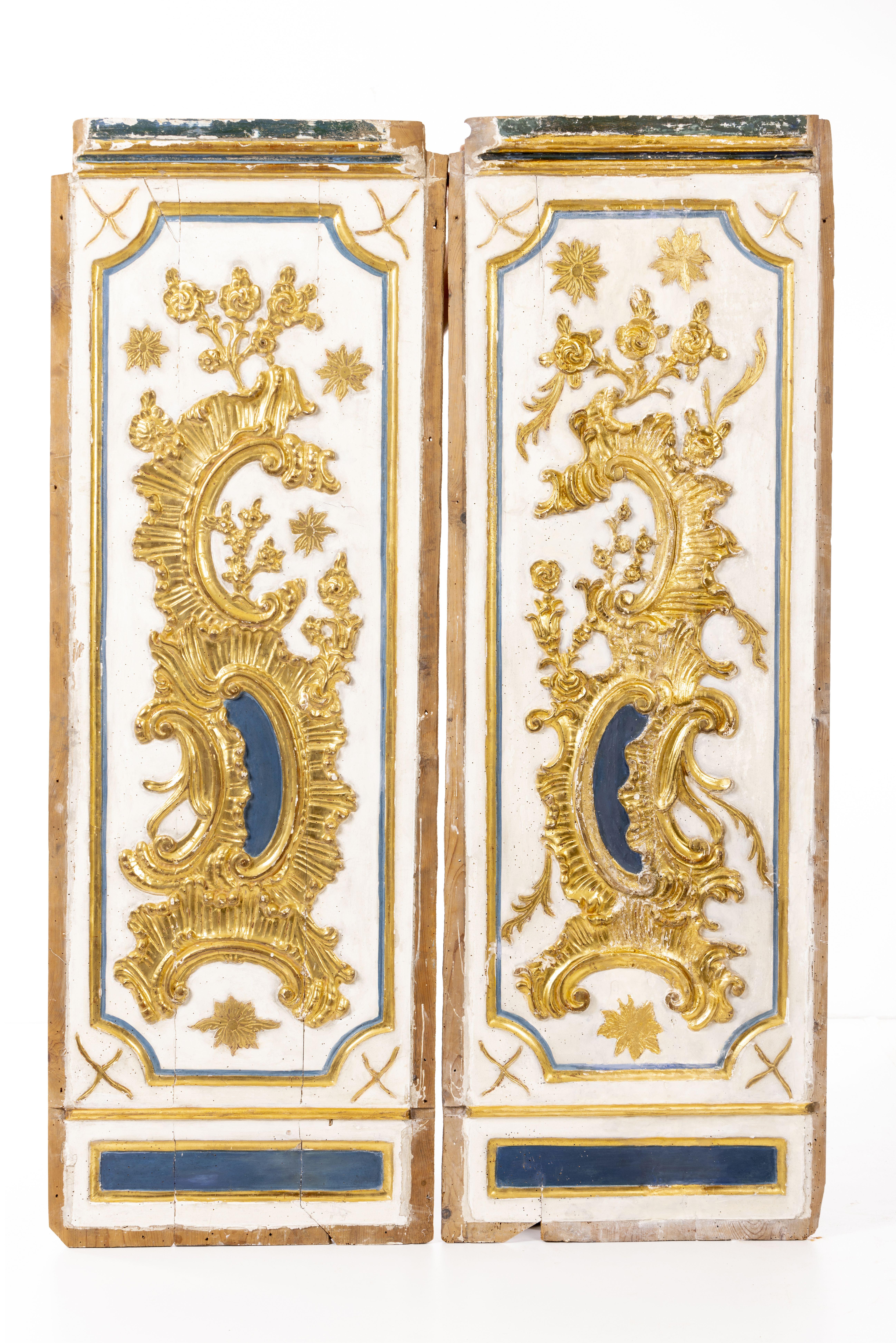 A fine and rare pair of Spanish Baroque carved giltwood boiserie panels, with part polychrome decoration showing exquisite carving of rocaille floral and shell elements.