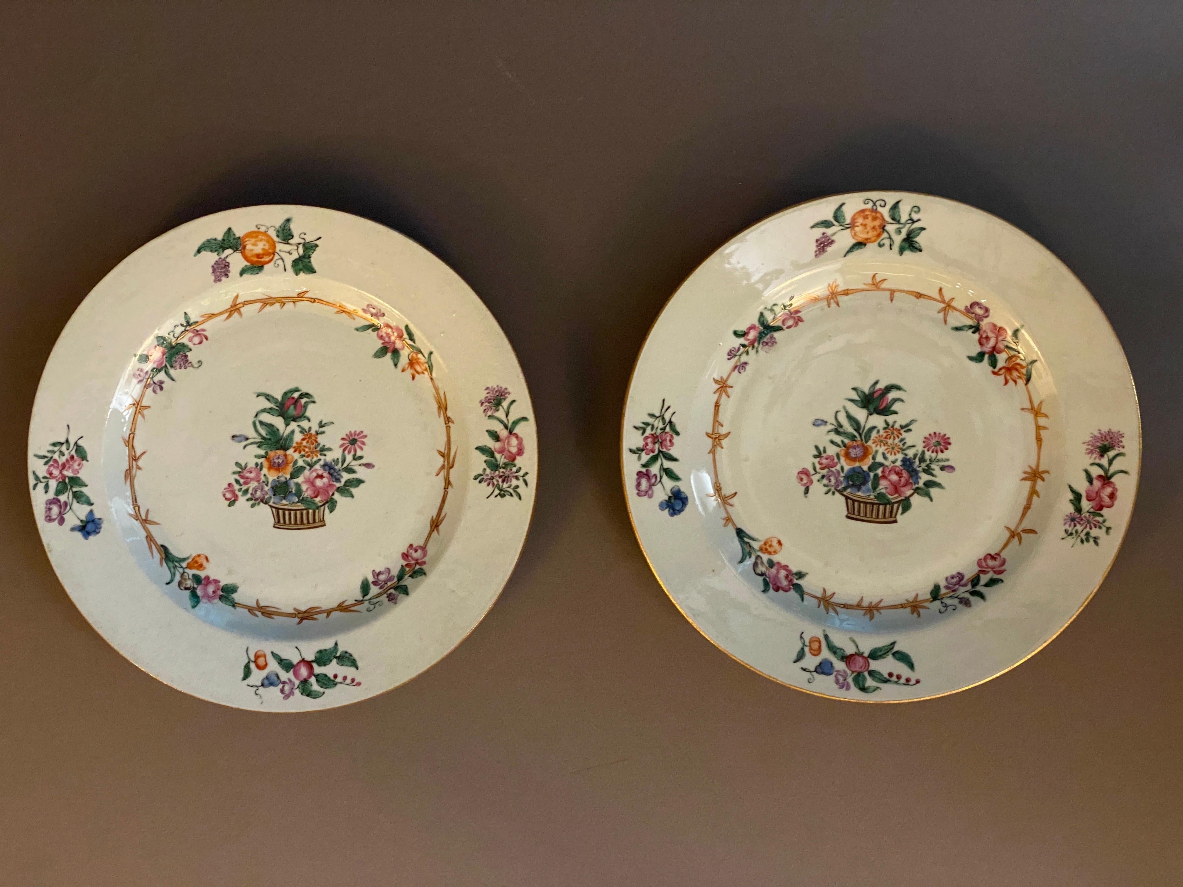 Paire d'assiettes en porcelaine famille rose de la Compagnie des Indes orientales du XVIIIe siècle à décor polychrome et doré de panier, de fleurs et de bambous.

Légère usure de l'émail. L'un d'entre eux présente un très petit éclat sur le bord