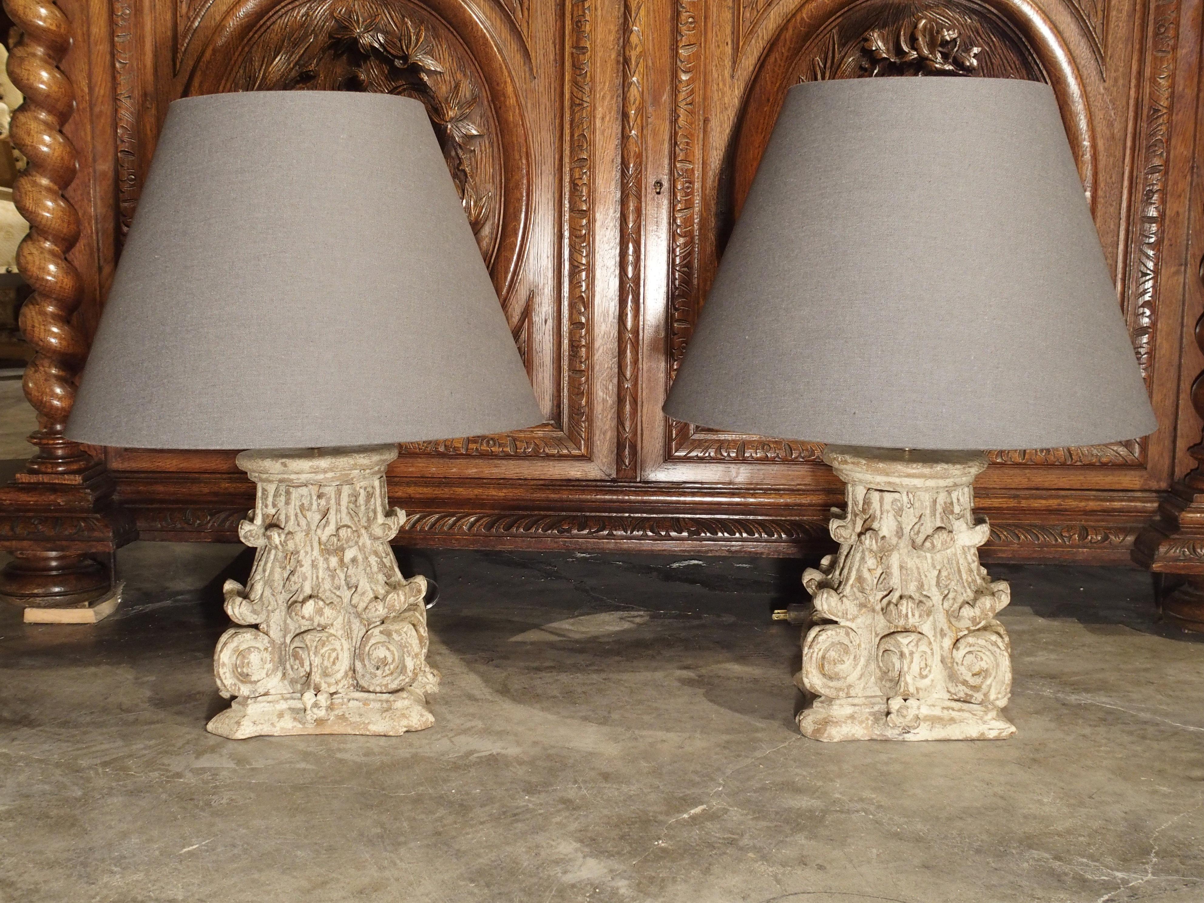 This pair of 18th century French oak column capitals have been turned into wonderful table lamps. The capitals are Corinthian style with acanthus leaf motifs, and they have a nice, worn whitewash parcel paint finish. We had them wired for use in the