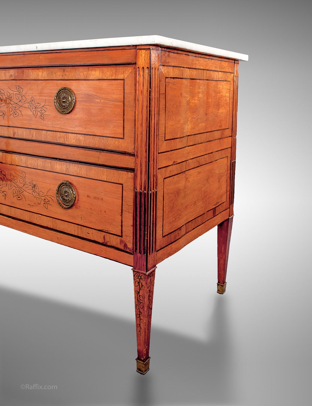 Elegant pair of 18th century Louis XVI period fruitwood commodes. Each two-drawer commode is raised by tapered legs. Above are two drawers with oval ormolu pulls and flower decorations. The top is marble and comes with two keys. Marble has been