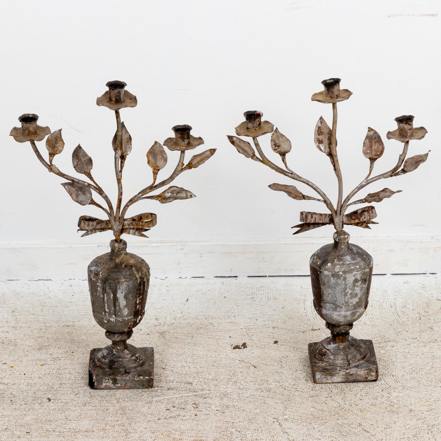 Circa 18th century pair of Continental silver giltwood candelabra, each feature three light candleholders with iron foliage on original urn form bases with ribbon bow. Possibly made in Italy. Please note of wear consistent with age. The candelabra