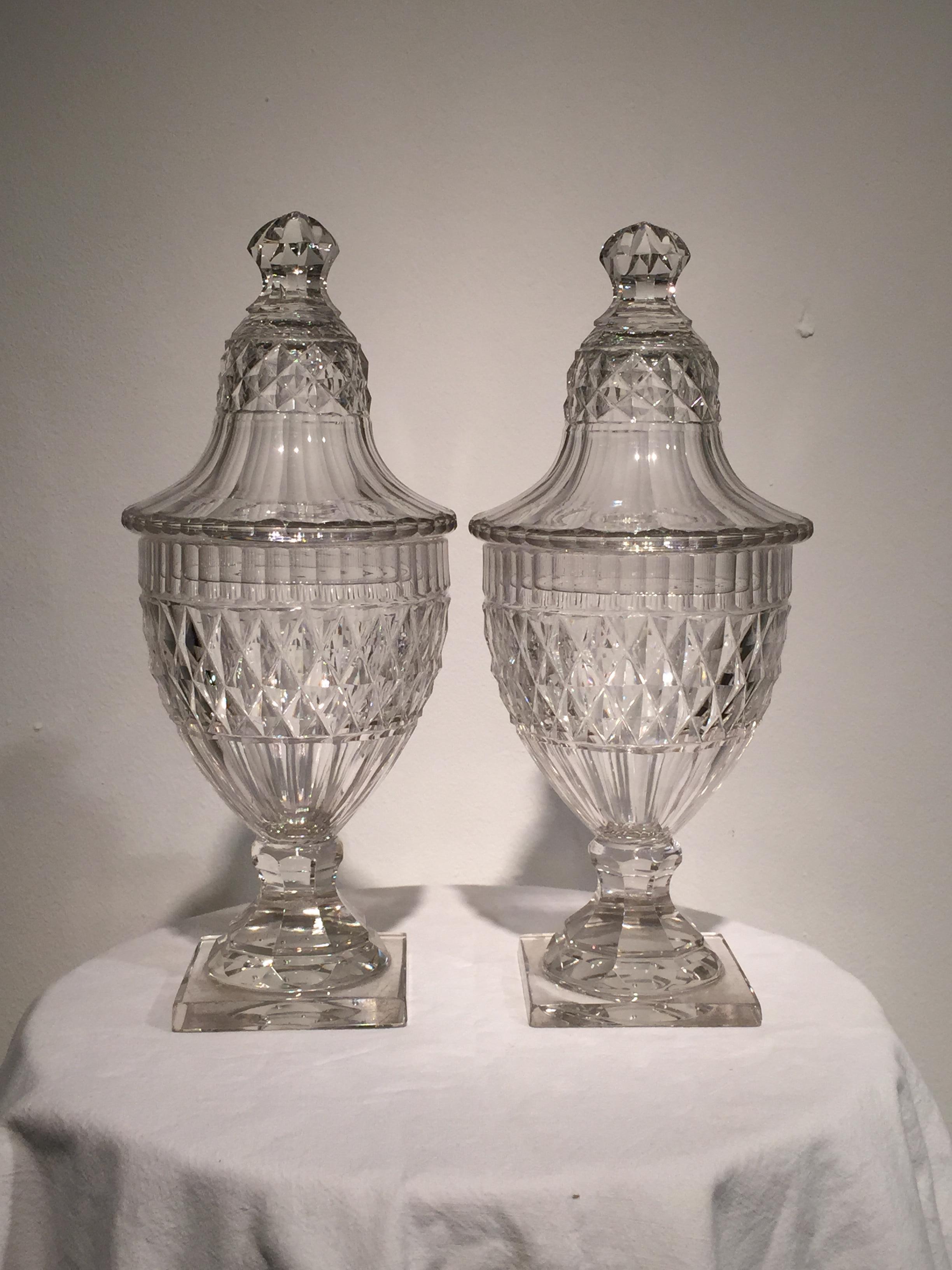 This fine and rare pair of jars and covers are of the finest quality. The lids with crown cut knop handles, hobnail and facet cutting and scalloped edge, the jar as above on square bases.
The 18th century lead crystal with fine grey hue as one