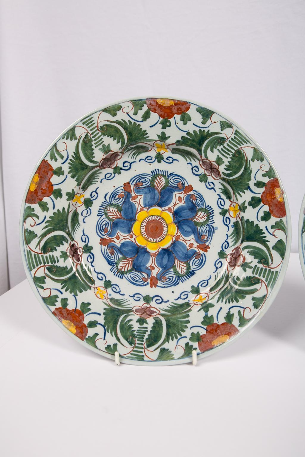 A pair of 18th century Delft chargers painted with a burst of polychrome colors: green, blue, orange, and yellow. The design is a geometric interpretation of tulips. The lively all-over design is outstanding.
Dimensions: 12 inches