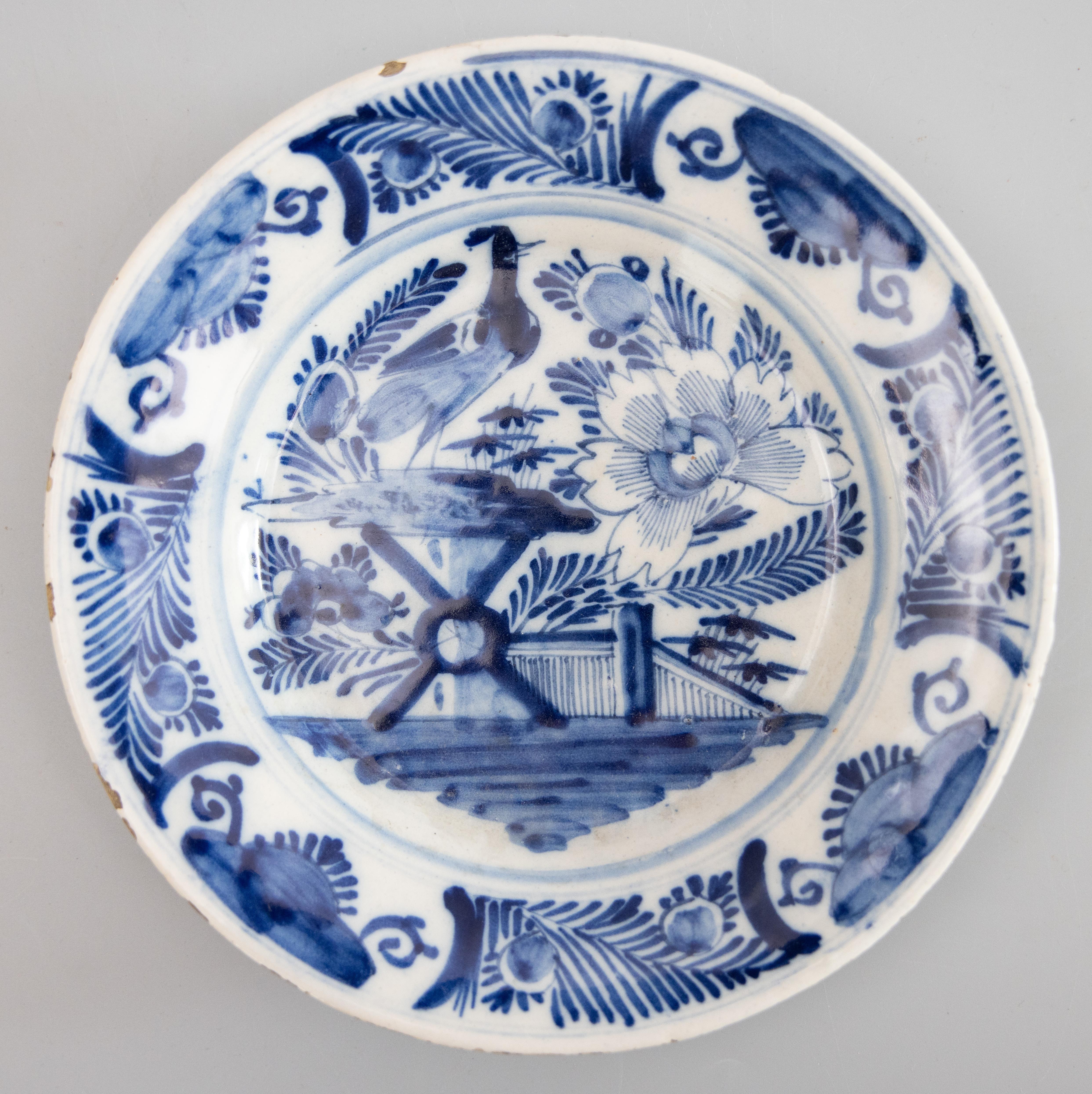 A superb pair of antique 18th-Century Dutch Delft Chinoiserie faience flower garden plates. These lovely plates have hand painted flowers, fence, birds, fruit and foliate border in cobalt blue and white. They would be wonderful displayed on a wall