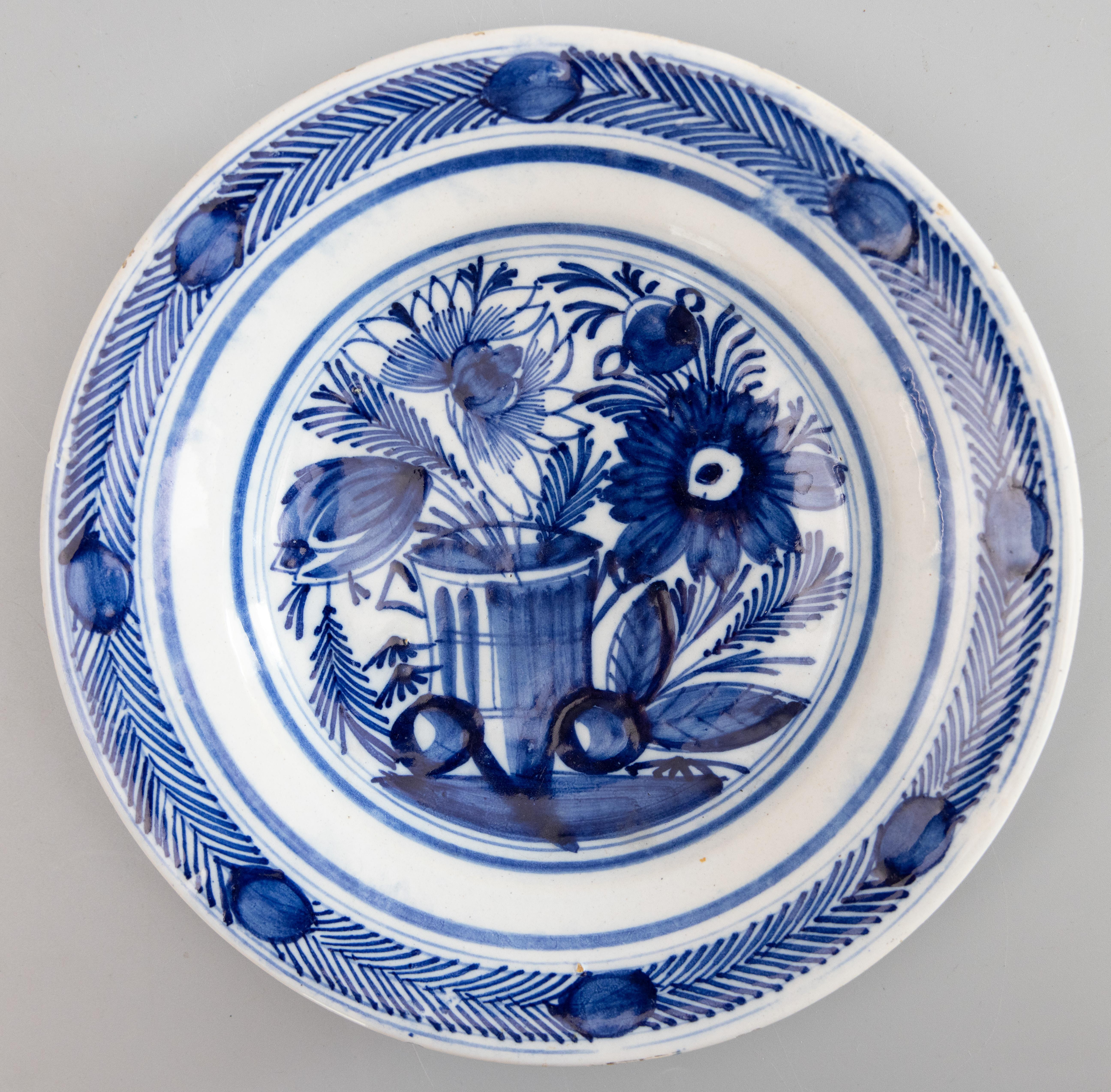 A gorgeous pair of antique 18th-Century Dutch Delft faience flower garden plates. These lovely plates have a hand painted floral and foliate design in vibrant cobalt blue and white. They would look fabulous displayed on a wall or in a cabinet.