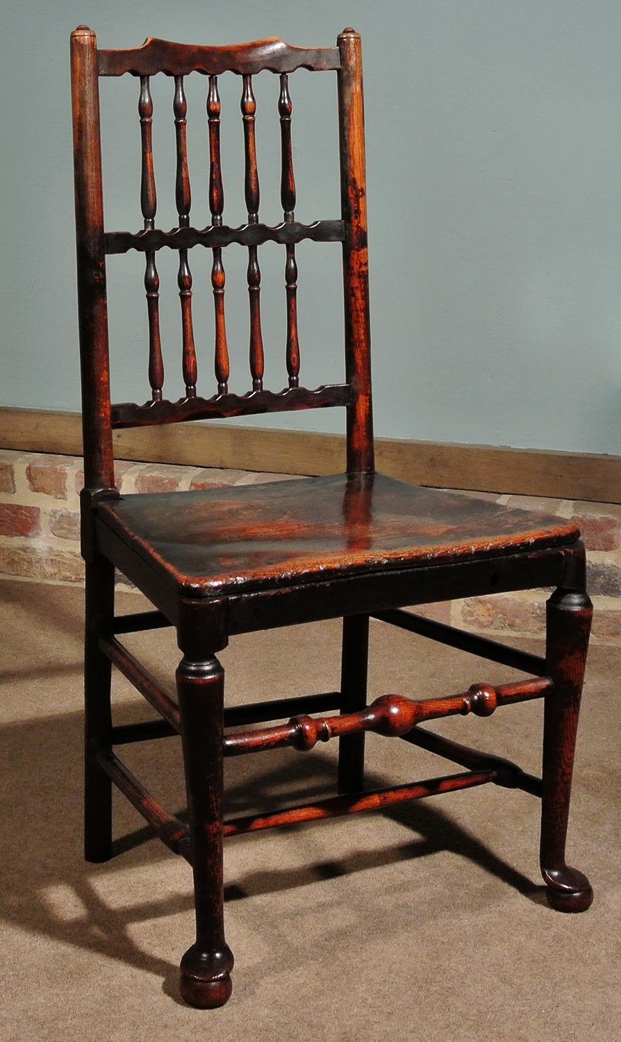 A very good pair of mid-18th century elm spindle back chairs. Of charming form and with a fantastic color and deep natural patination, the chairs are solid and robust and extremely eye-catching.

Original and complete spindles and stretchers, all