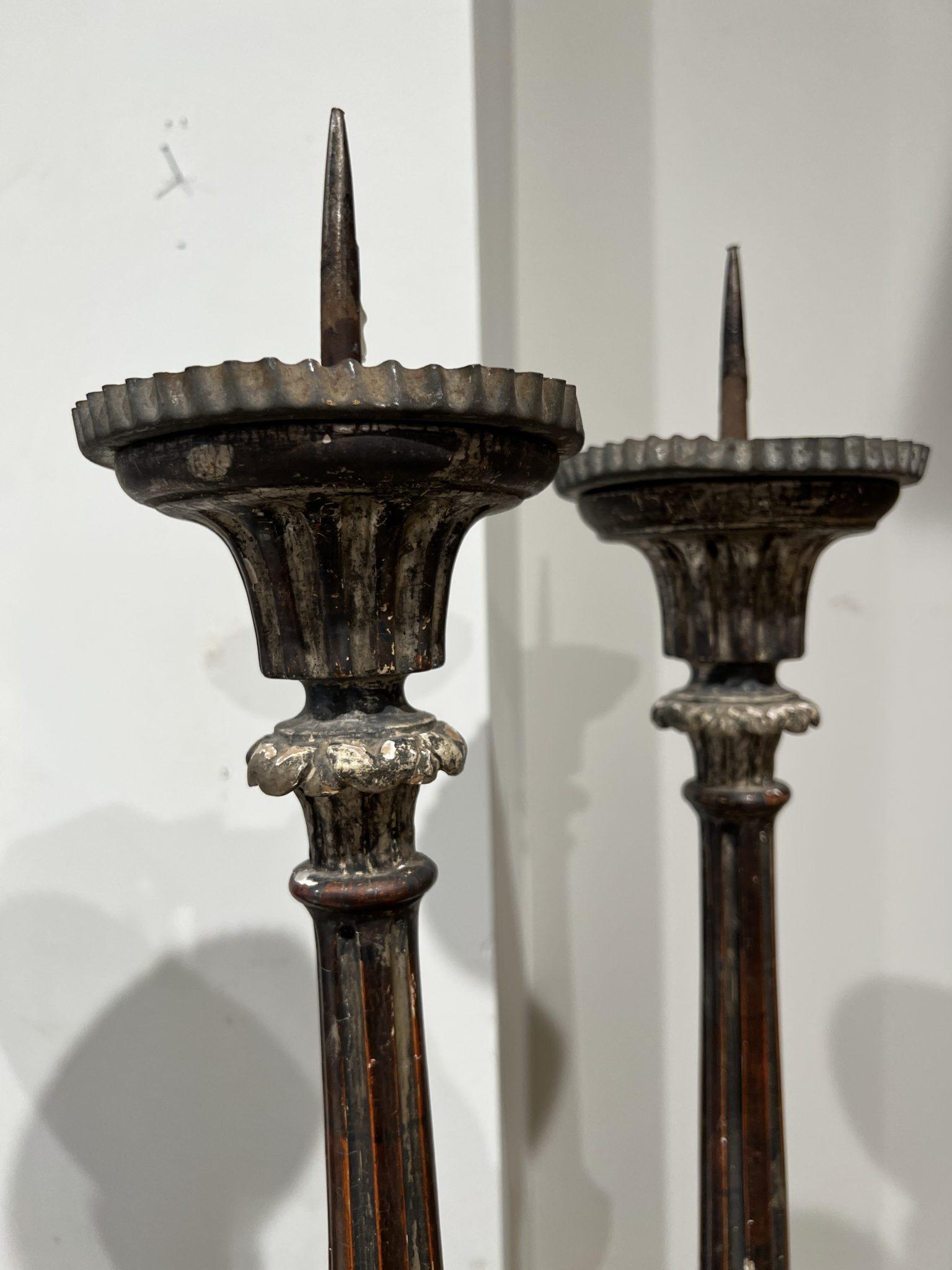 Tall candlesticks with beautiful details. Tin drip trays and spikes. Two sets of two are available. One has a repaired bun foot.