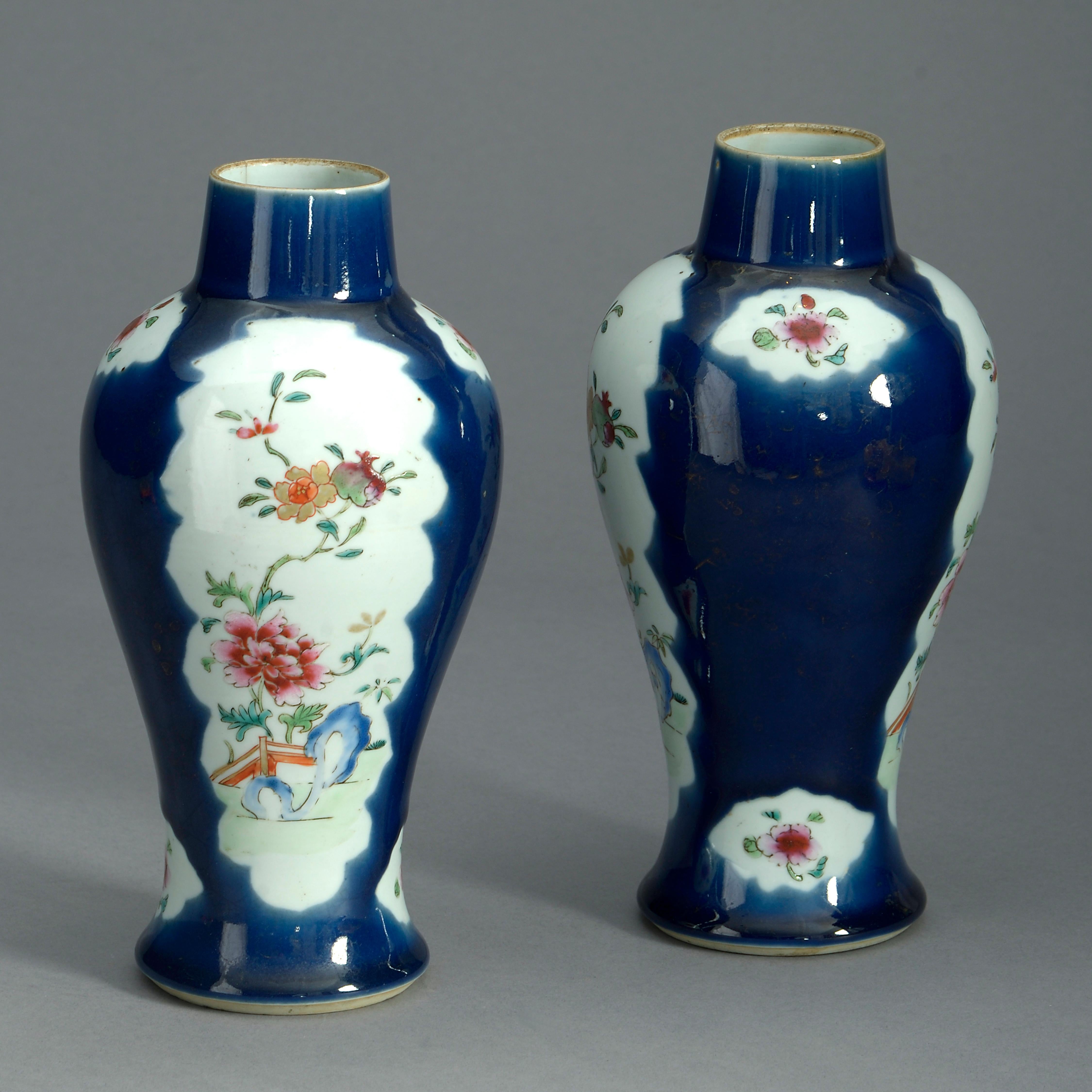 A pair of mid-18th century famille rose porcelain baluster vases, the leaf shaped cartouches with floral motifs set within deep blue grounds retaining traces of gilded “cracked ice” and blossom motifs. One neck with hairline.

Qing Dynasty,