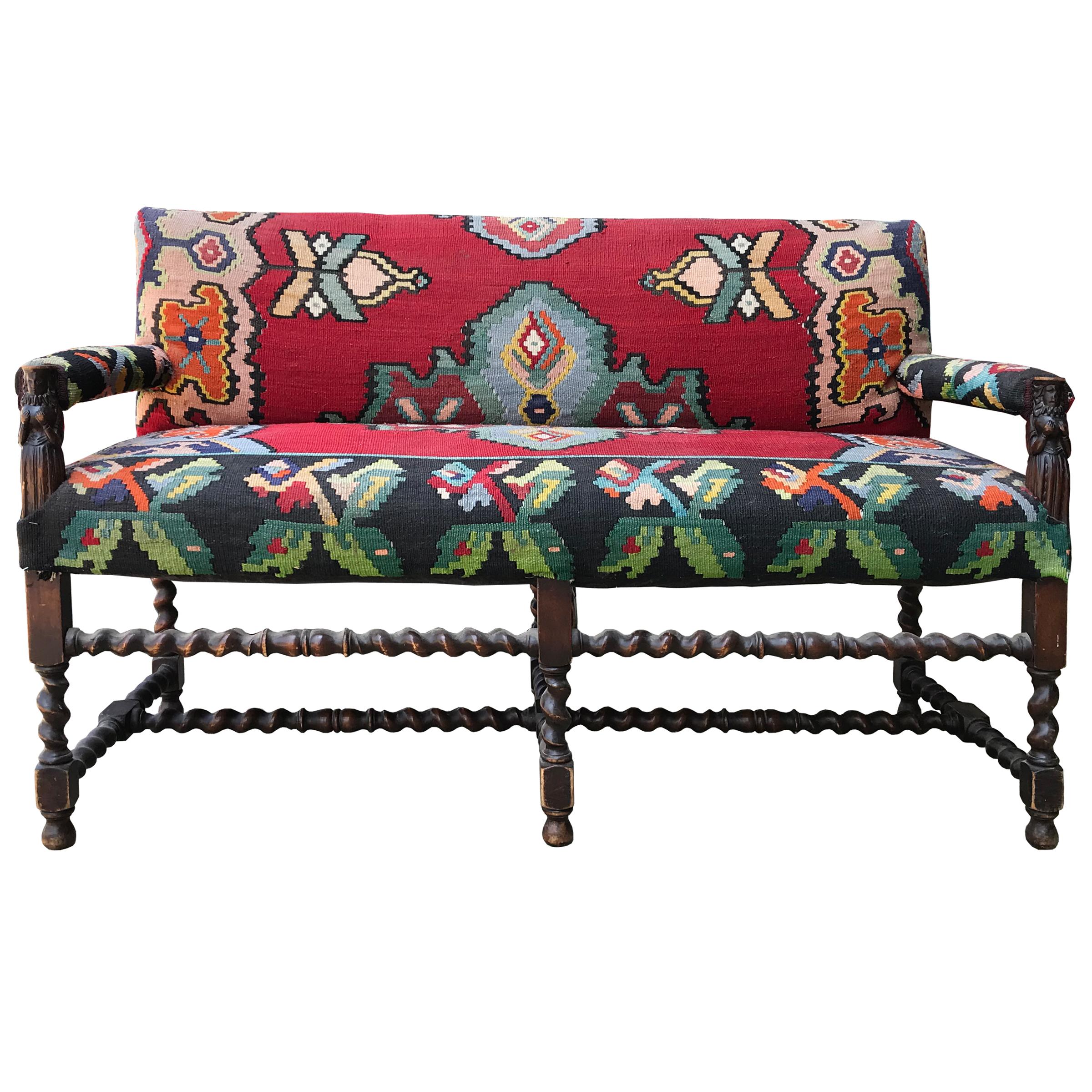 A pair of wonderful 18th century Flemish benches with carved wood barley twist legs and stretchers, figural arm stands depicting women with Elizabethan collars holding their bosoms, and upholstered in matching vintage 20th century Turkish Kilim