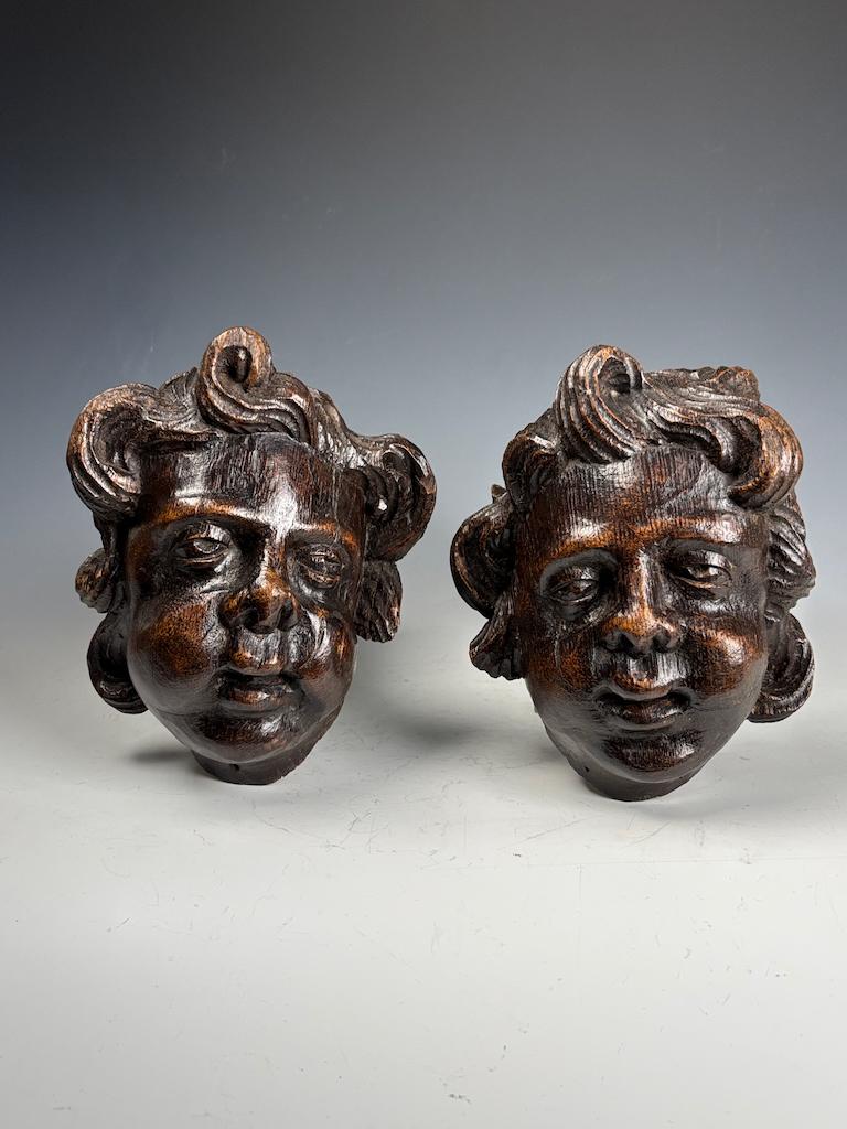 Pair of 18th Century Flemish Carved Wooden Cherub (Putto) Heads

A striking pair of hand-carved wooden cherub heads dating to the 18th century, originating from Flanders (present-day Belgium). These expressive putti—plump, angelic child figures—are