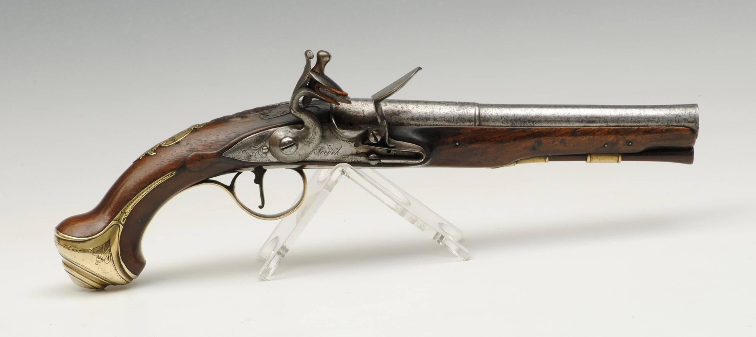 A pair of brass-mounted 22 bore gentleman's flintlock holster pistols with two stage barrels signed on the lock by T.Pocock. The walnut stocks with chased and cast brass mounts including an engraved cartouche with a stags head, Birmingham proof