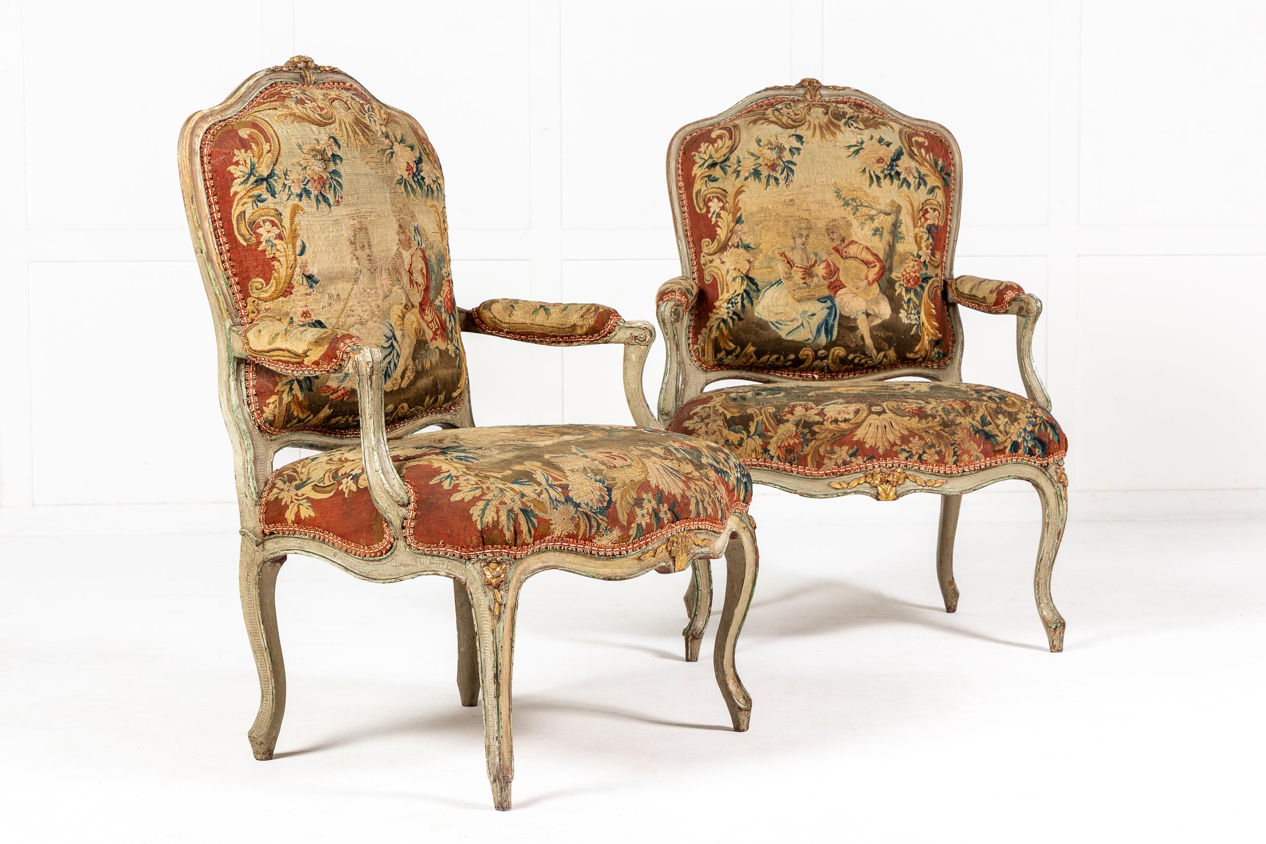 A rare pair of curvaceous 18th century French chairs with their original Abusson tapestry and original paint and gilding. They have slightly slanting backs with curved tops with pretty and decorative carved details to the top crest, apron and