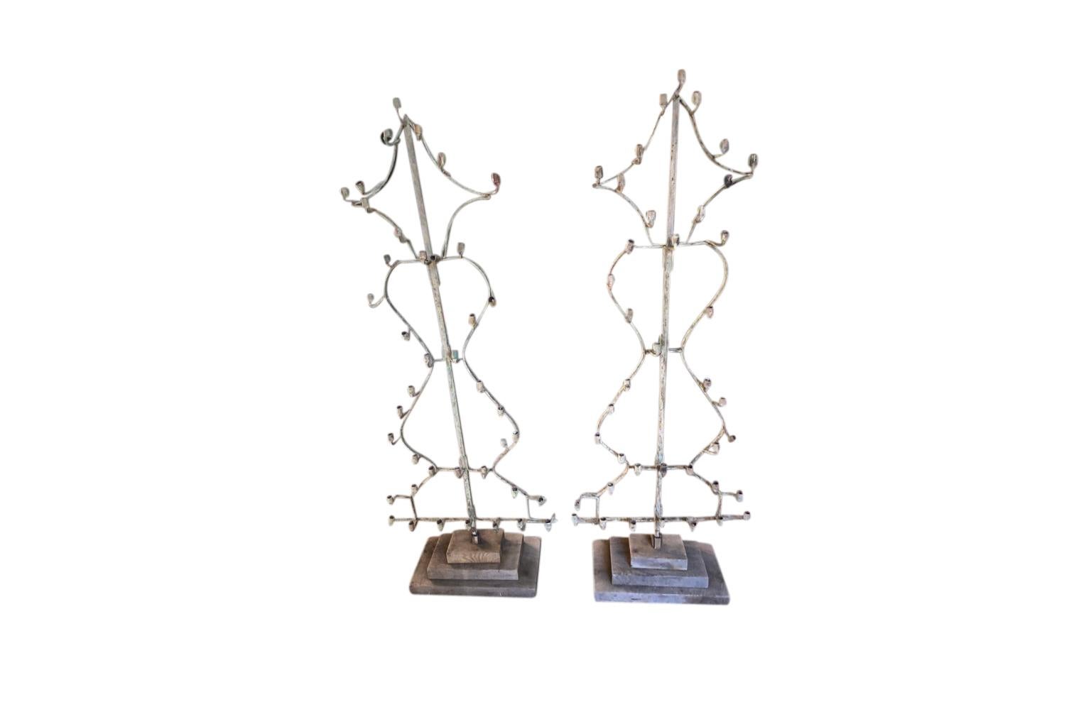 A stunning and very unusual pair of later 18th century Candelabra - Appliques - Sconces crafted from hand forged iron with riveting. The candelabra now stand in their removable wooden bases. These fabulous light fixtures are perfect for candles or