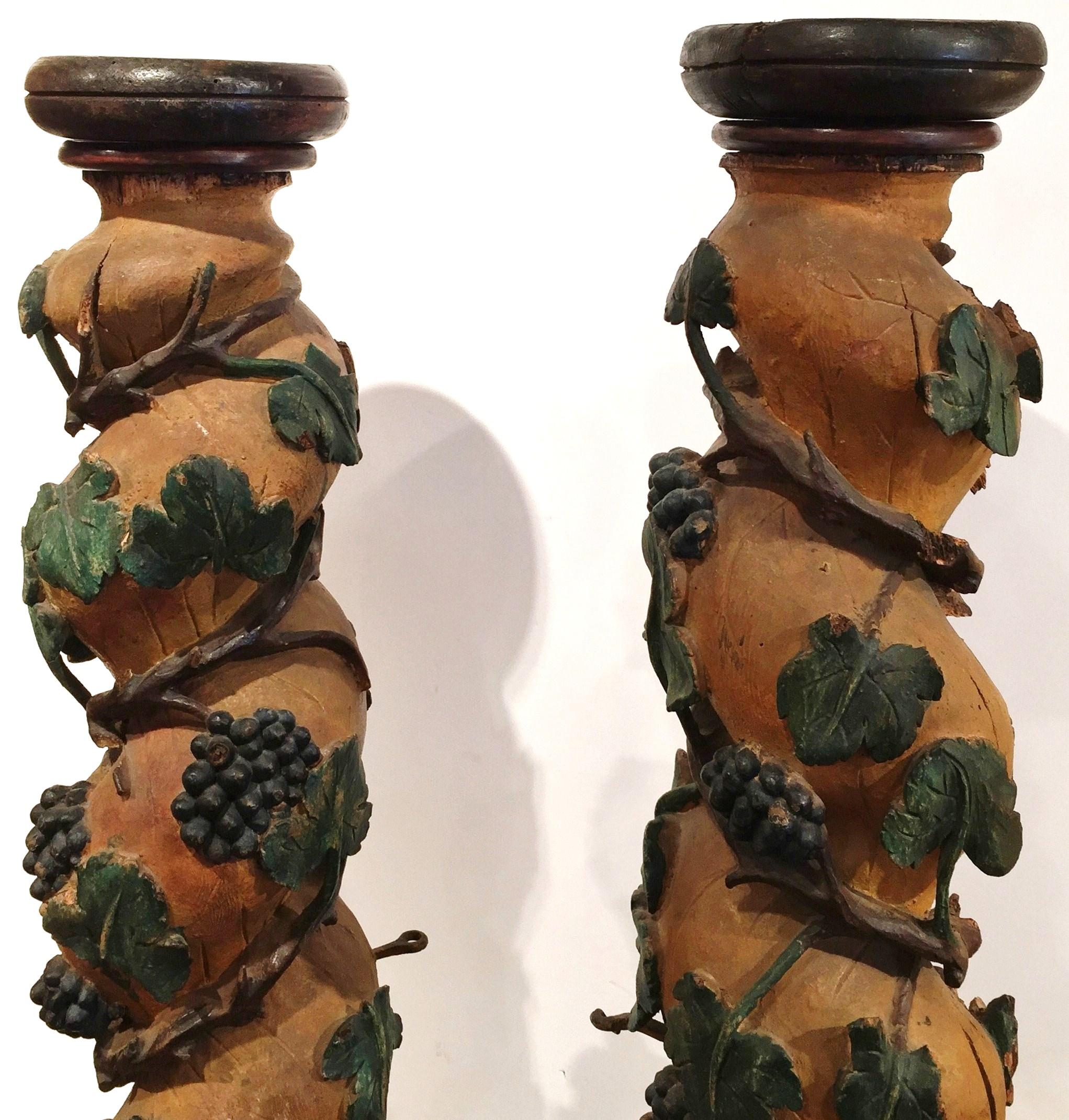 Decorate your wine cellar with these antique, carved columns. Hand carved in France, circa 1750, the tall painted carvings have a sturdy square base at the bottom and a rounded plate at the top. Each of the scrolling columns has a wine theme that