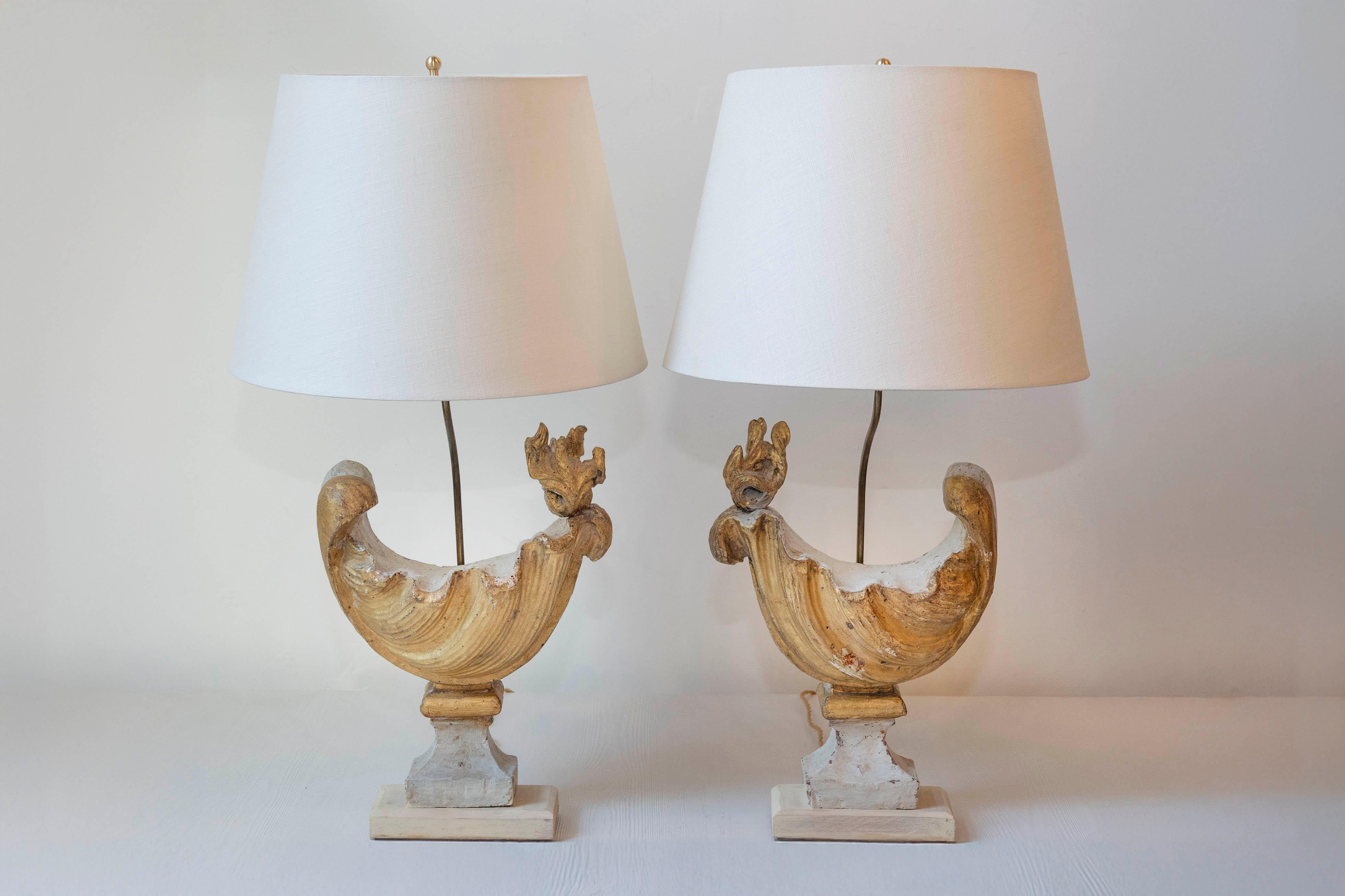 This unique pair of 18th-century French lamps features a design inspired by traditional decorative urns or cornucopias, often seen in classical French decor. Each lamp has a sculptural base resembling a stylized rooster or bird shape, crafted from