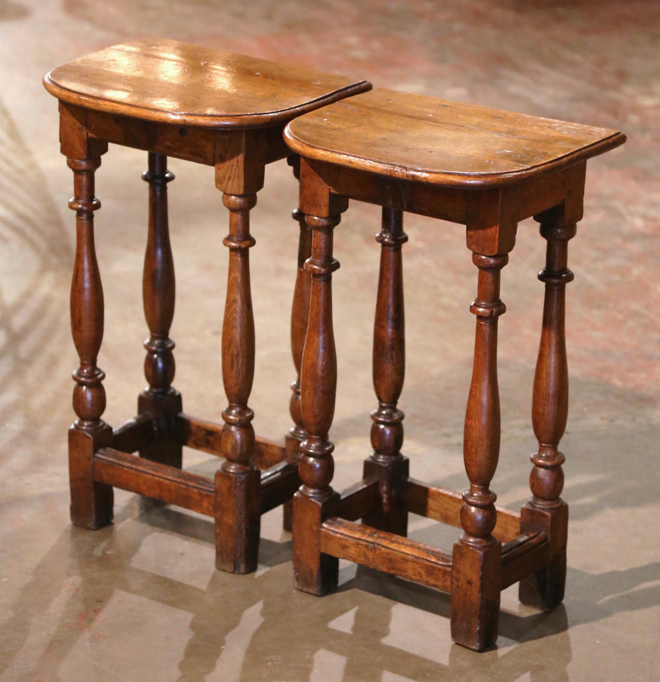 This elegant antique side tables were created in Normandy, France circa 1780. Built of oak and attached with pegs, each piece stands on four turned legs connected with a sturdy stretcher at the bottom. The top surface is curved across the front. The