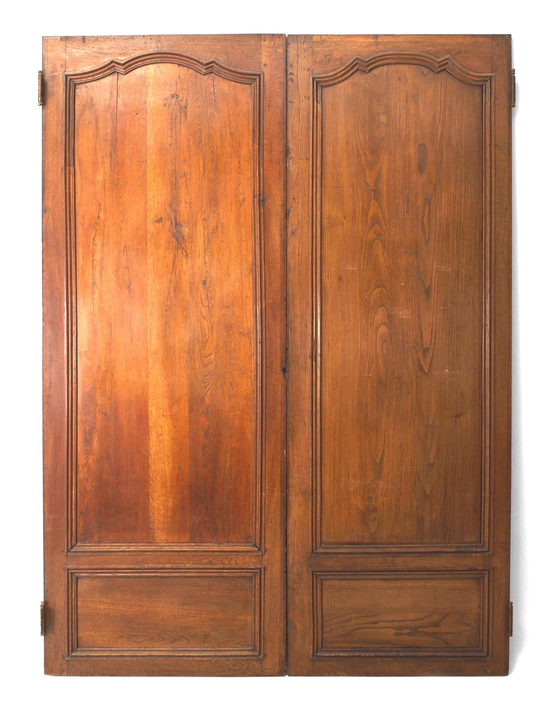 Pair of French Provincial (18th Century) similarly sized walnut door panels with a shaped top molding, unfinished on back. (PRICED AS Pair).
