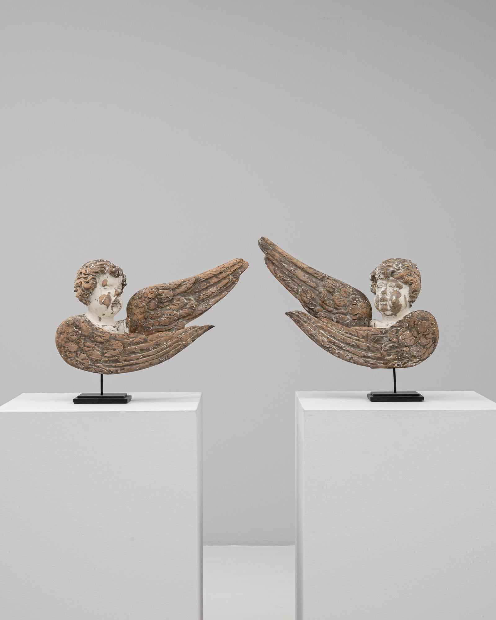 Questa coppia di angeli francesi in legno intagliato del XVIII secolo incarna il fascino e la poesia dell'arte ecclesiastica del periodo. Ogni figura è raffigurata come un serafino alato, con volti espressivi e morbidamente modellati e ali piumate