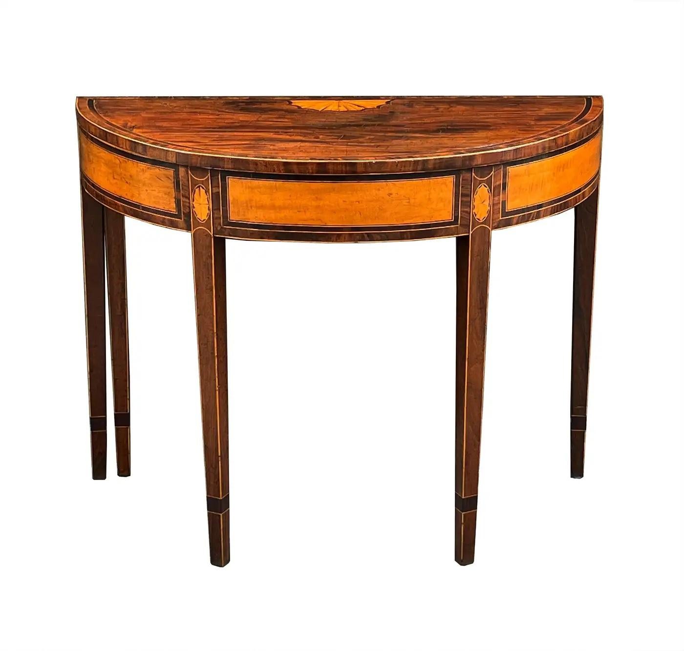 A stunning pair of 18th century Georgian mahogany and satinwood inlaid demilunes. Beautifully figured mahogany lipped console tops with cross-banded edges are supported by a frieze of satinwood panels and stringing of boxwood and ebony. The tops of