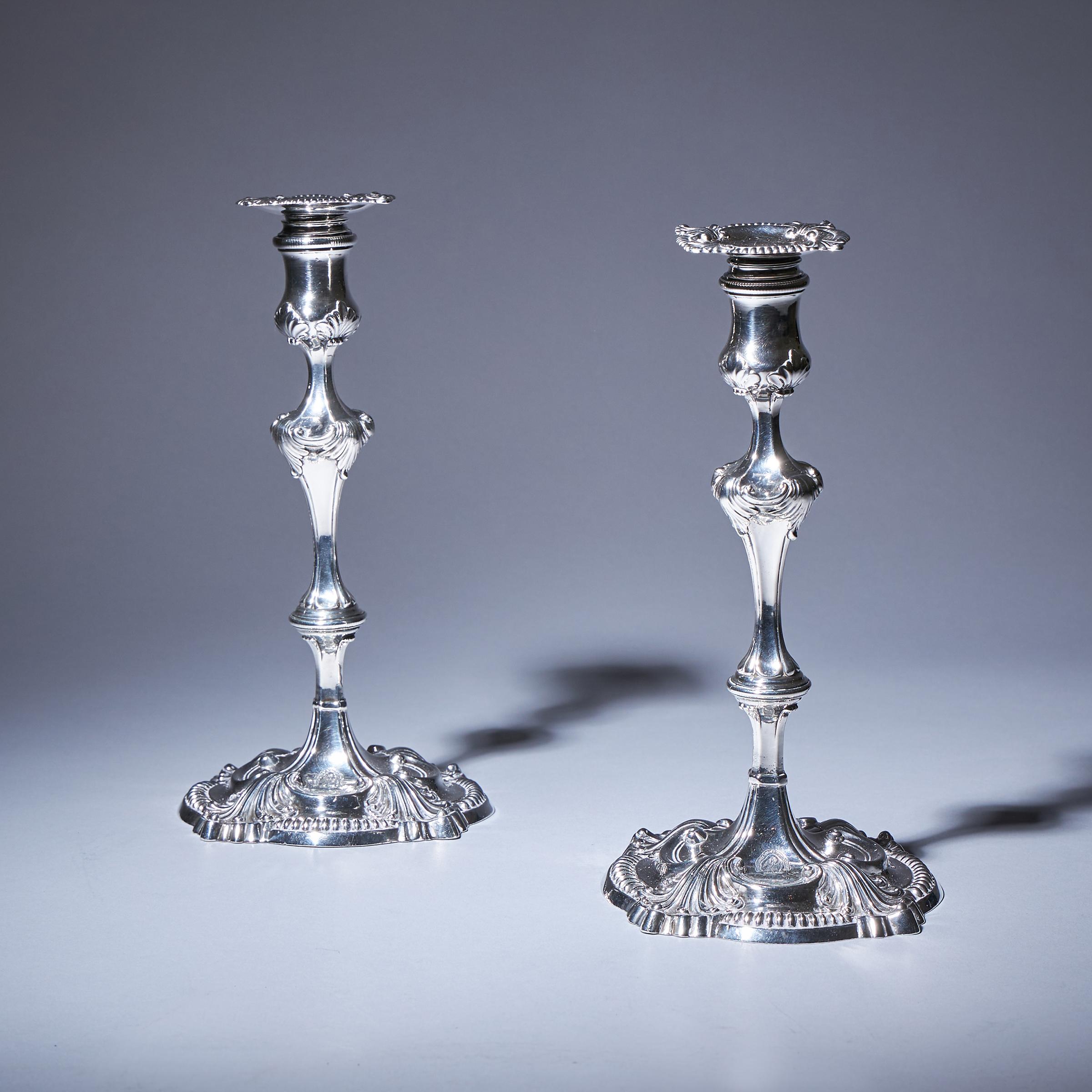 An outstanding pair of 18th-century Rocco George III silver candlesticks with original detachable sconces. 

Made in London, 1762 by David Bell. 

Each candlestick is in excellent condition, numbered No 1 and No 2, and features a full set of