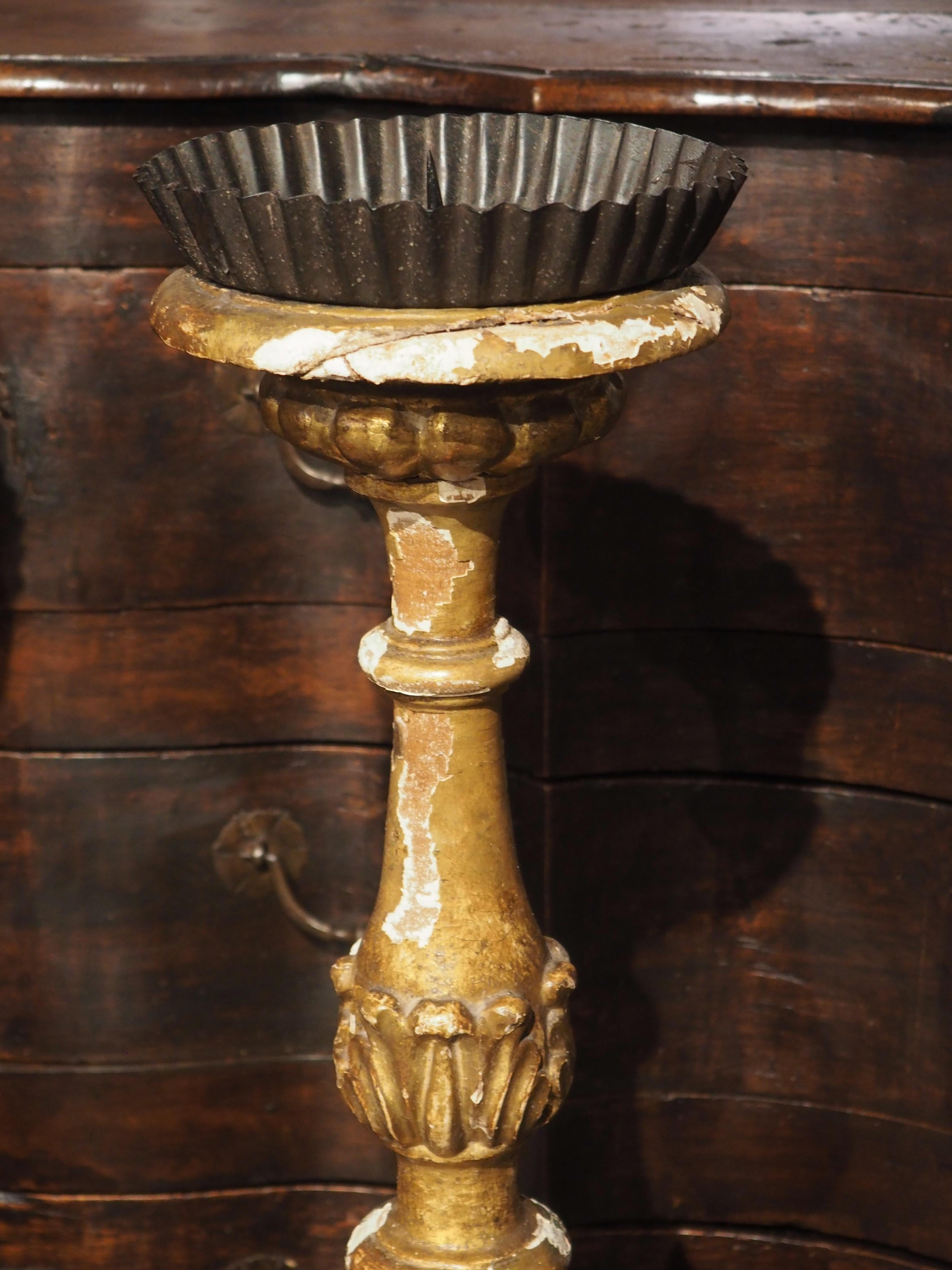 Hand-carved in France in the 1700’s, this pair of giltwood altar candlesticks has been adorned with foliate motifs and stylized paw feet. The finely detailed columns stand on tripartite bases and were completely carved on all sides.

The columns