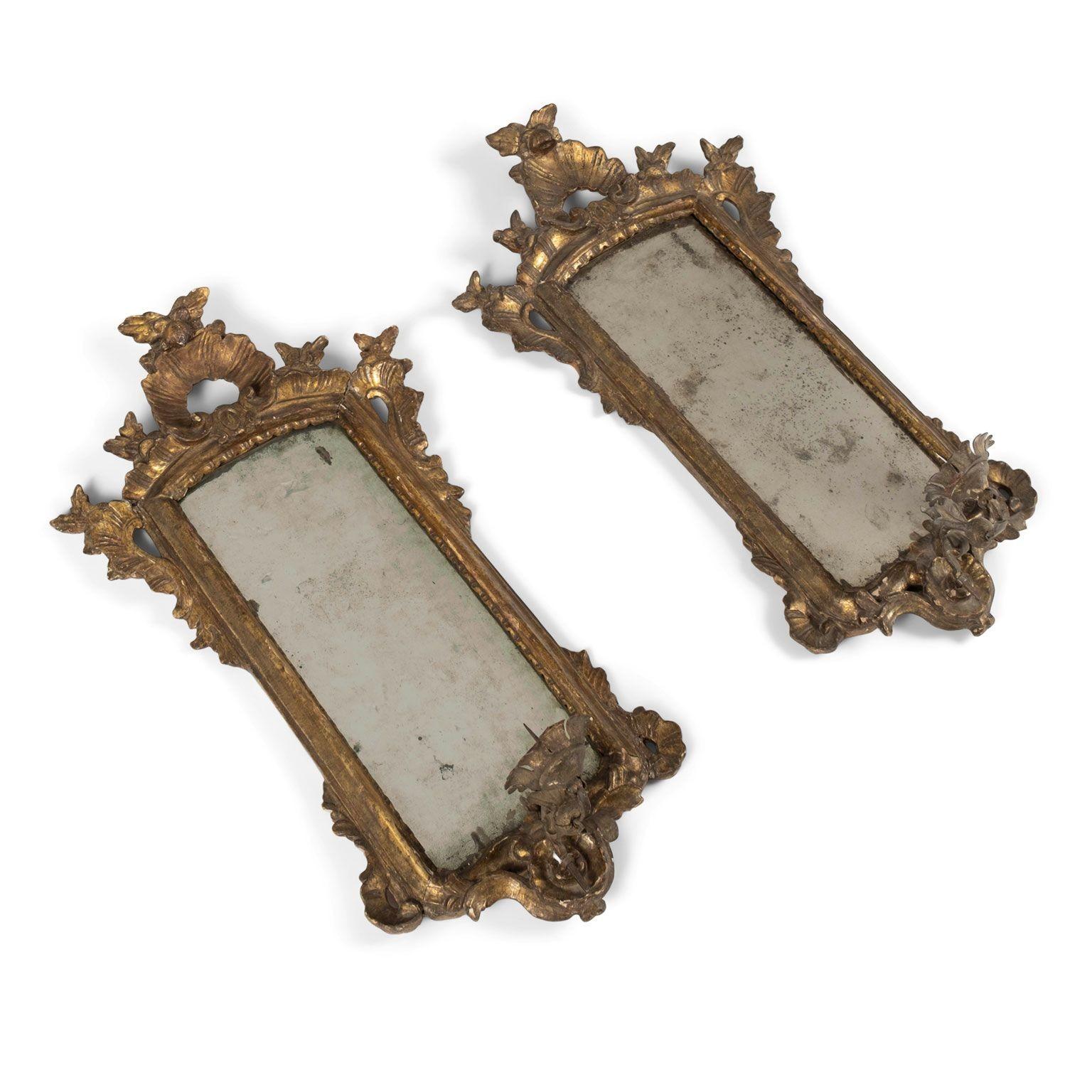 Paire d'appliques à miroir en bois doré du XVIIIe siècle. Vers 1750-1789. Sculptée et dorée à la main. Miroir précoce. Chaque projet prévoit un bras unique pour les bougies. Non câblé. Vendus ensemble au prix de 5 700 $ la paire.